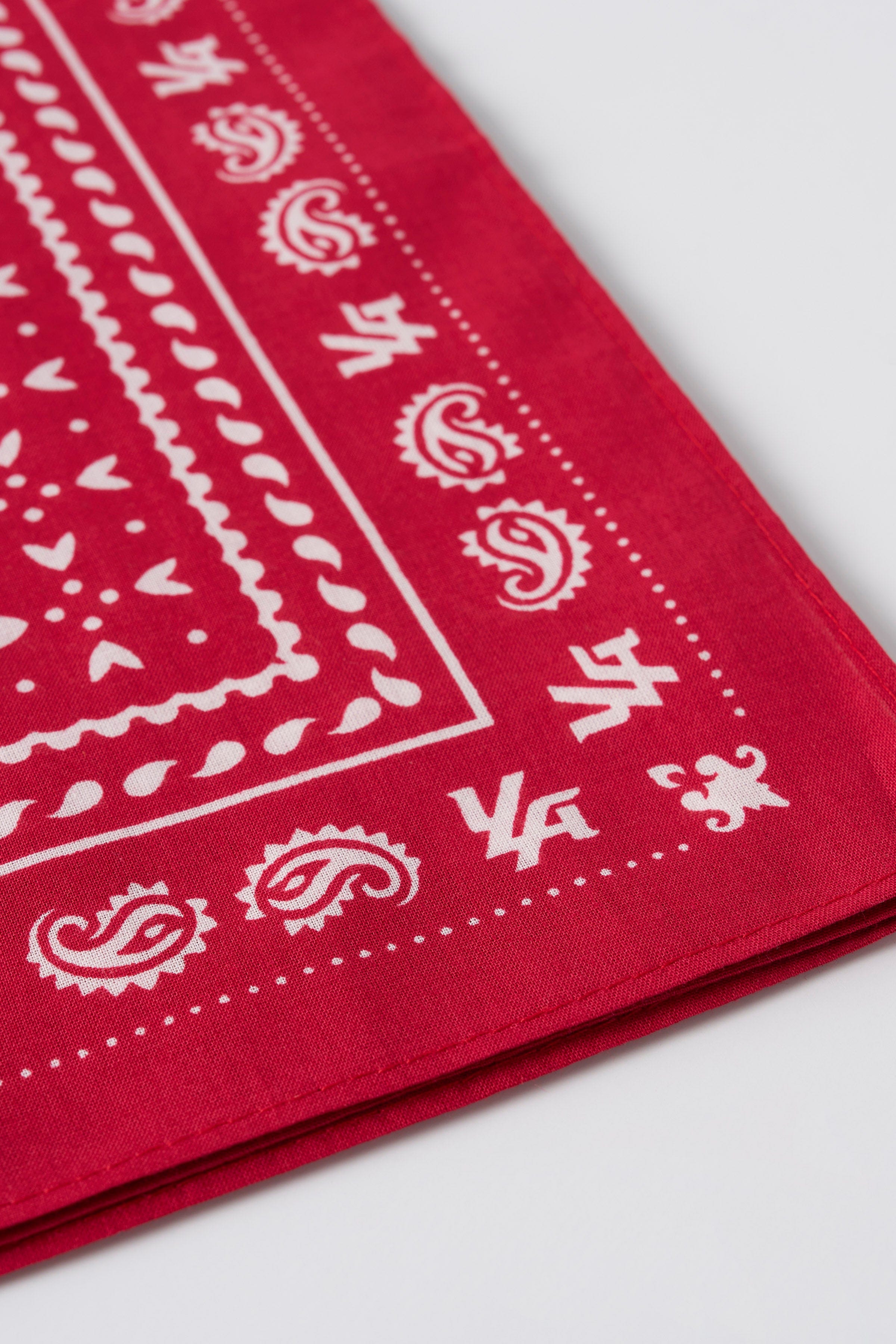 Bandana laid out flat on a wooden table beside BBQ skewers and fresh herbs