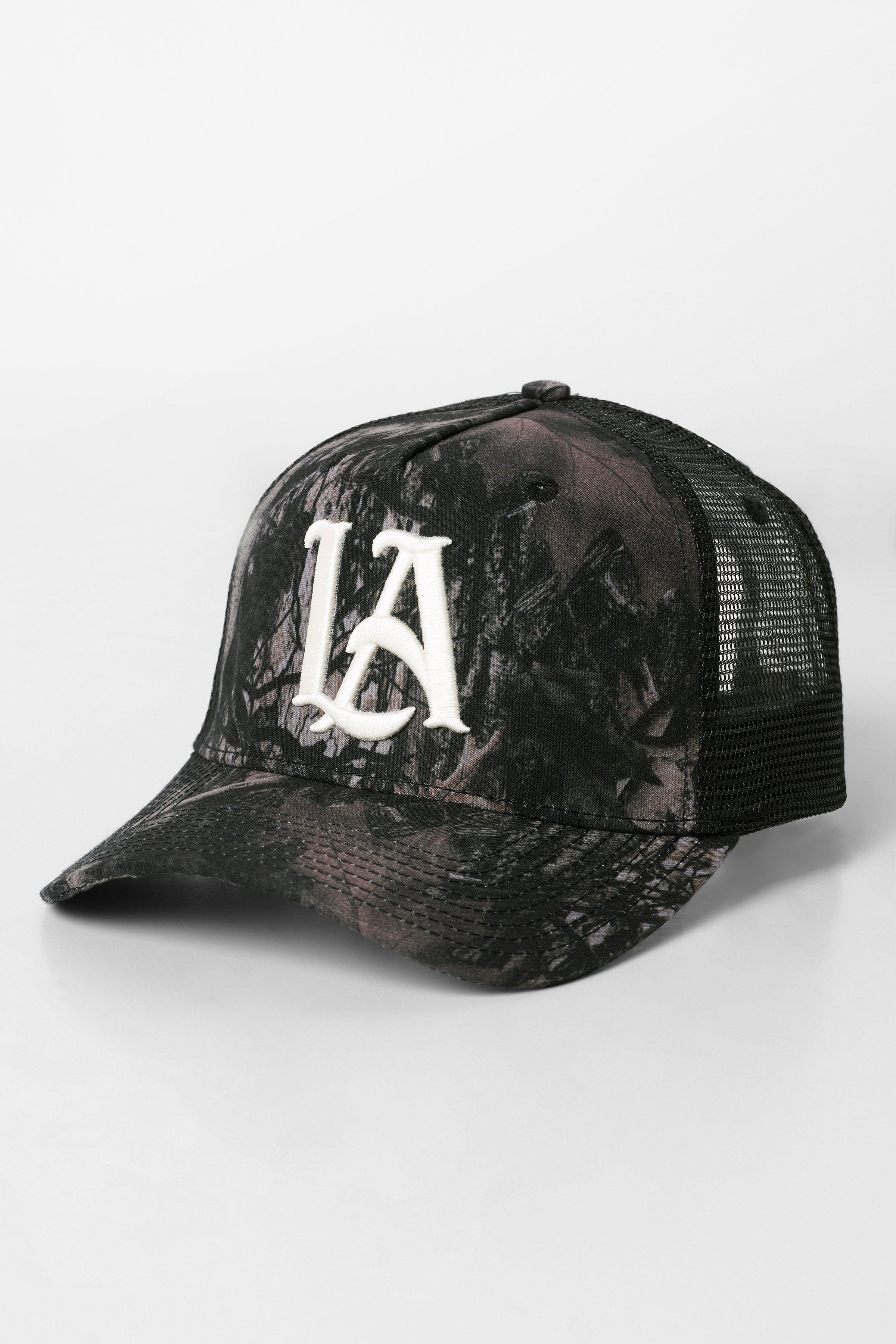 Front angle of camo trucker hat showing LA embroidery and tree camouflage
