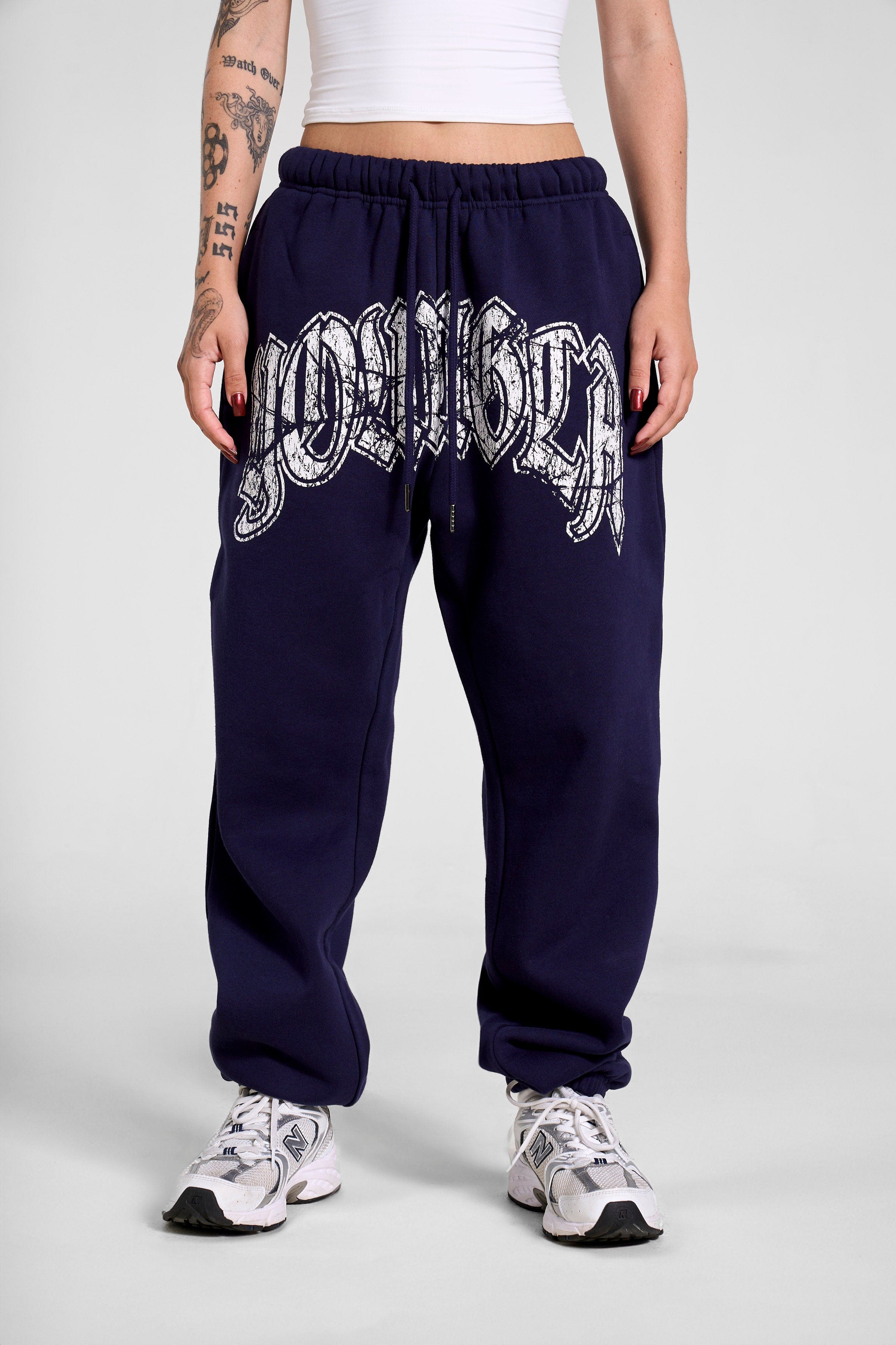 Front view of stylish black joggers for women with a cracked print logo.
