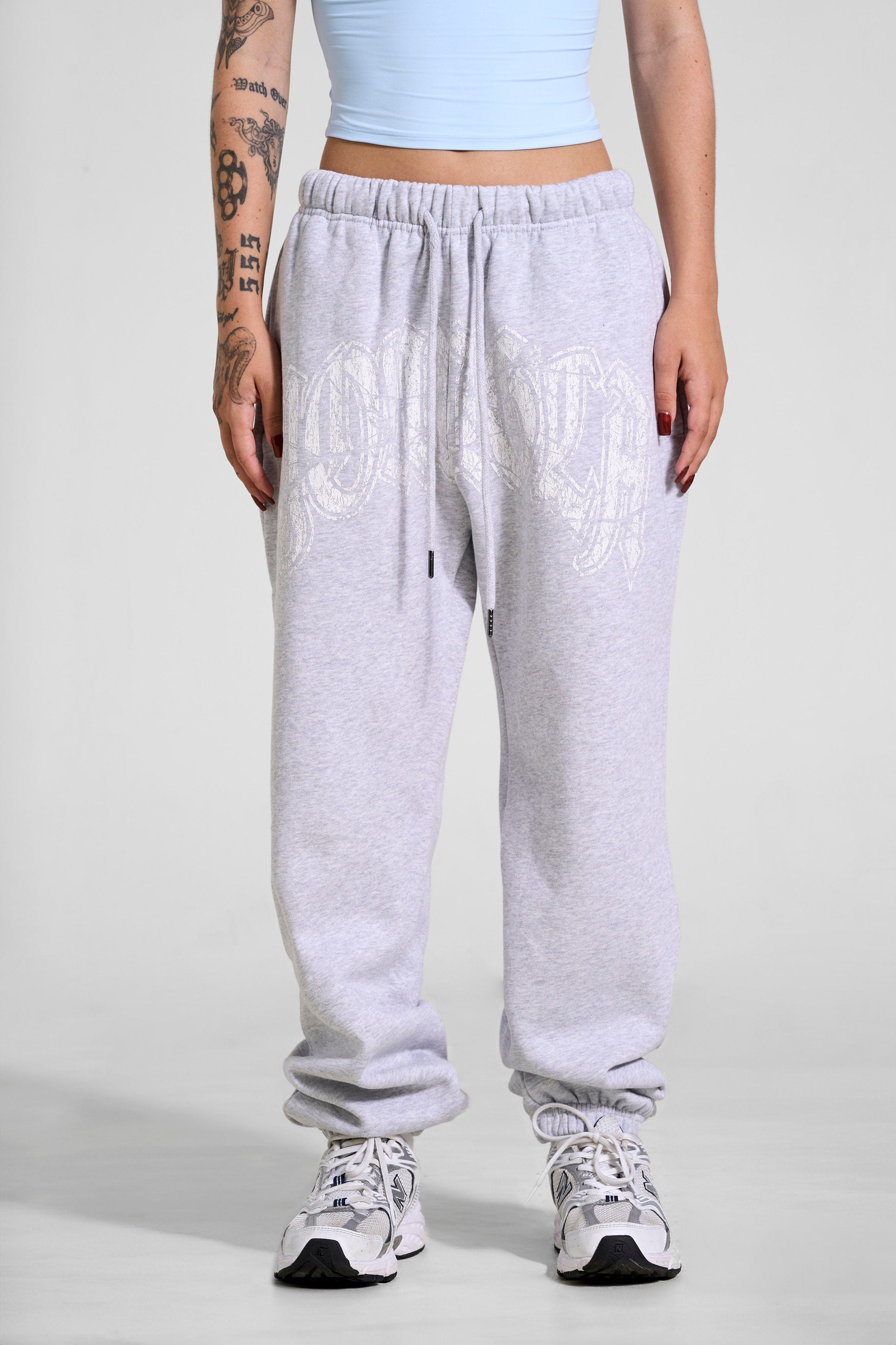 Front view of stylish black joggers for women with a cracked print logo.