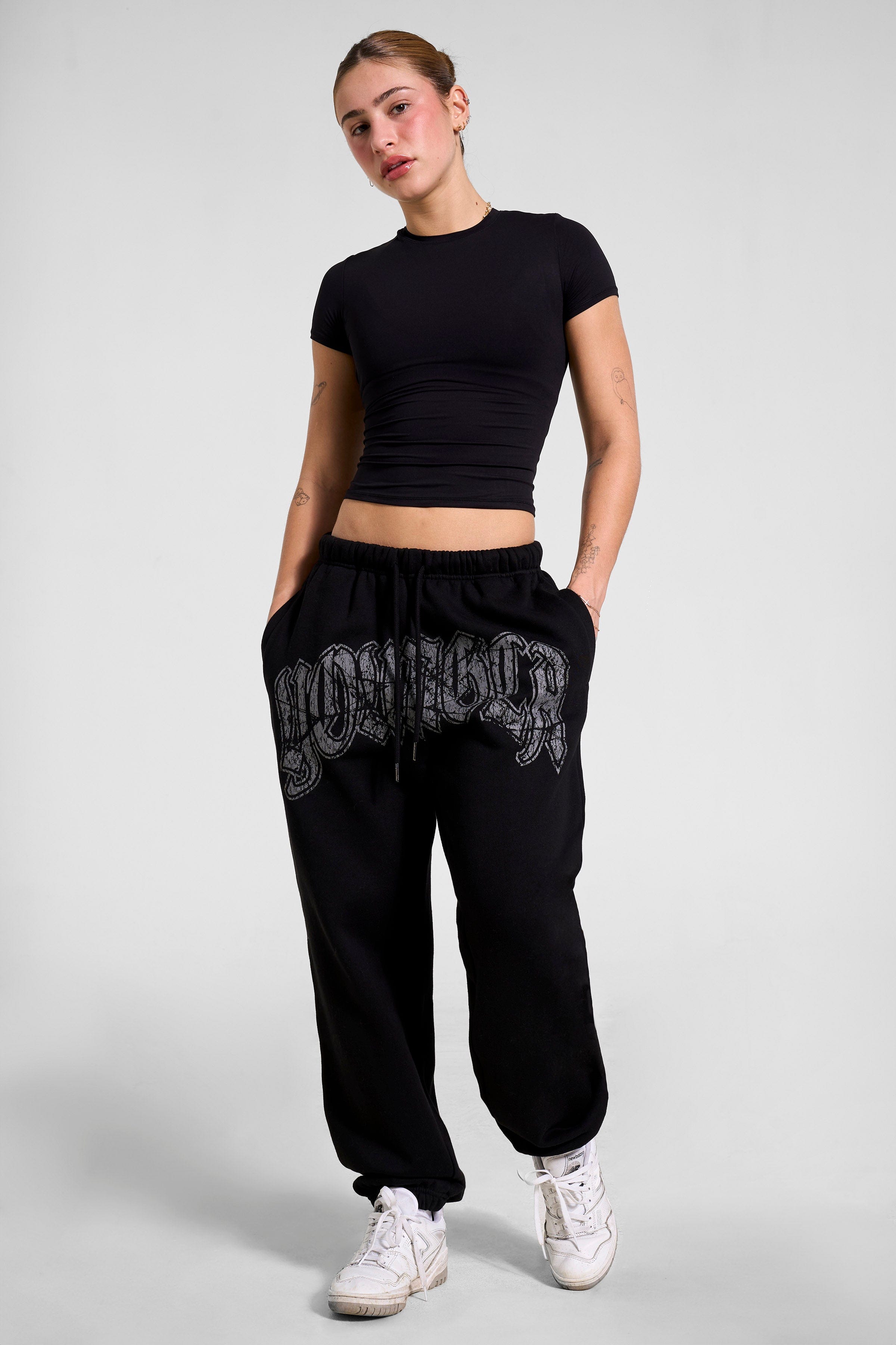 Model wearing black joggers, demonstrating a relaxed yet stylish look.