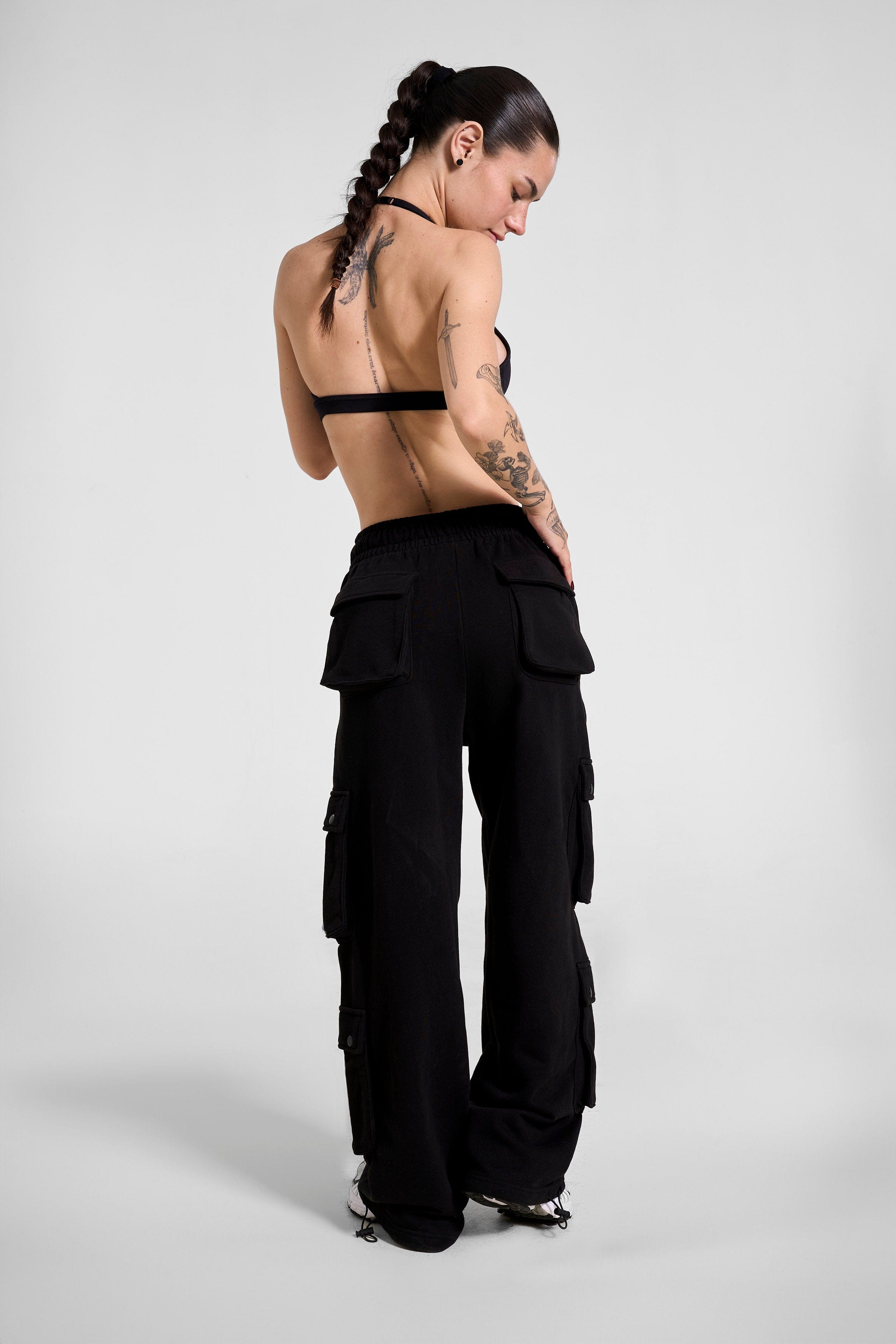 Model wearing black mens cargo joggers with functional pockets during a hiking trip