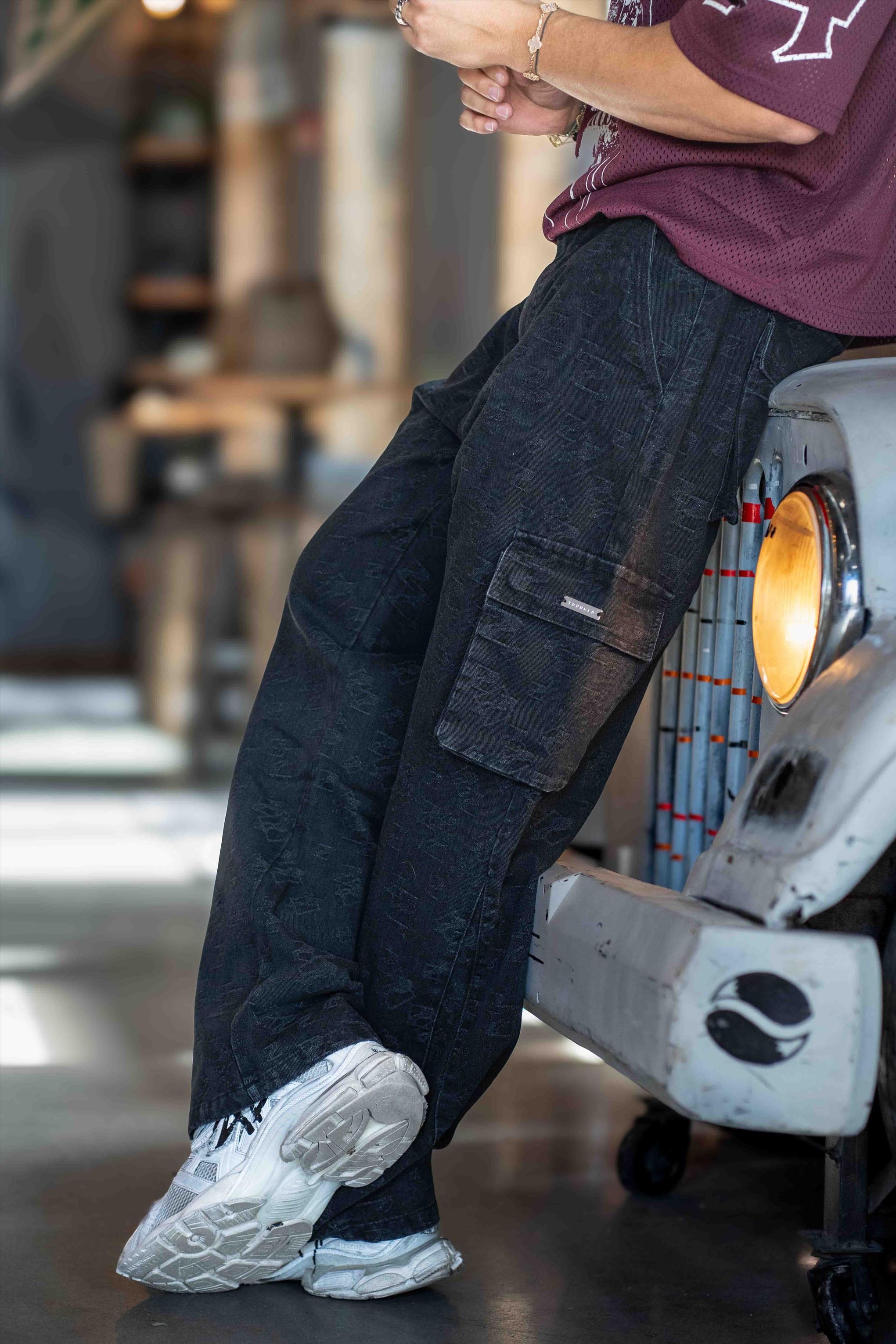 Close-up of cargo trouser jeans detailing metal tag and jacquard pattern