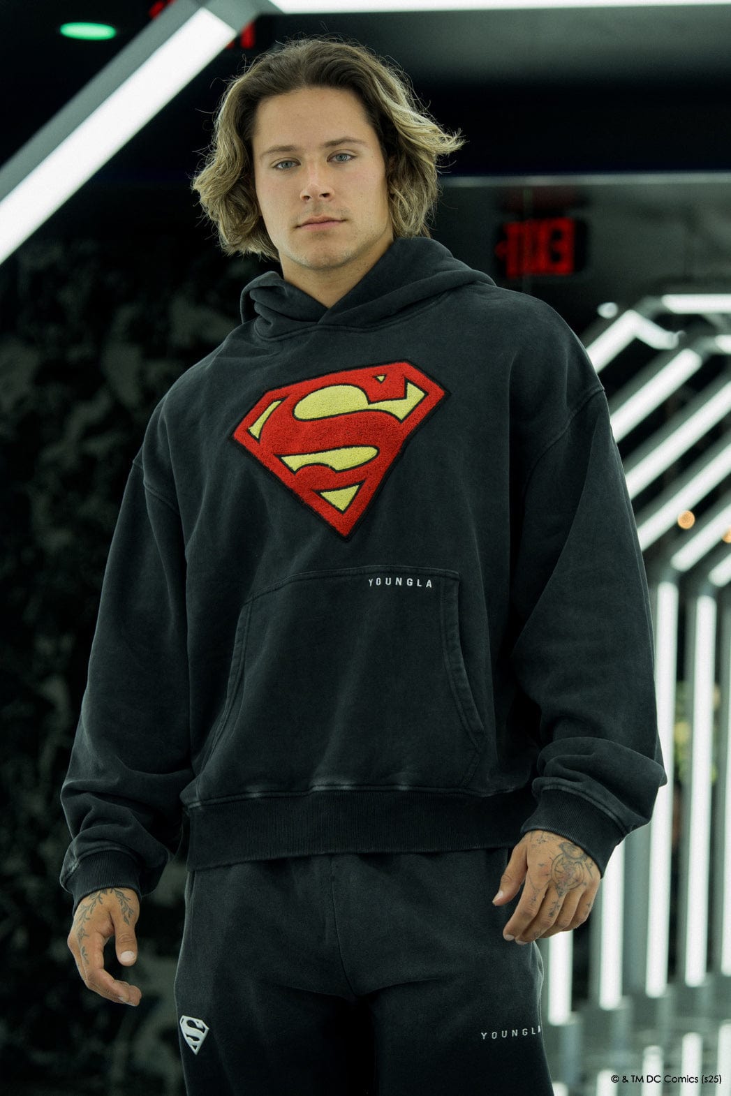Model wearing the Superman Legacy hoodie in a casual setting.