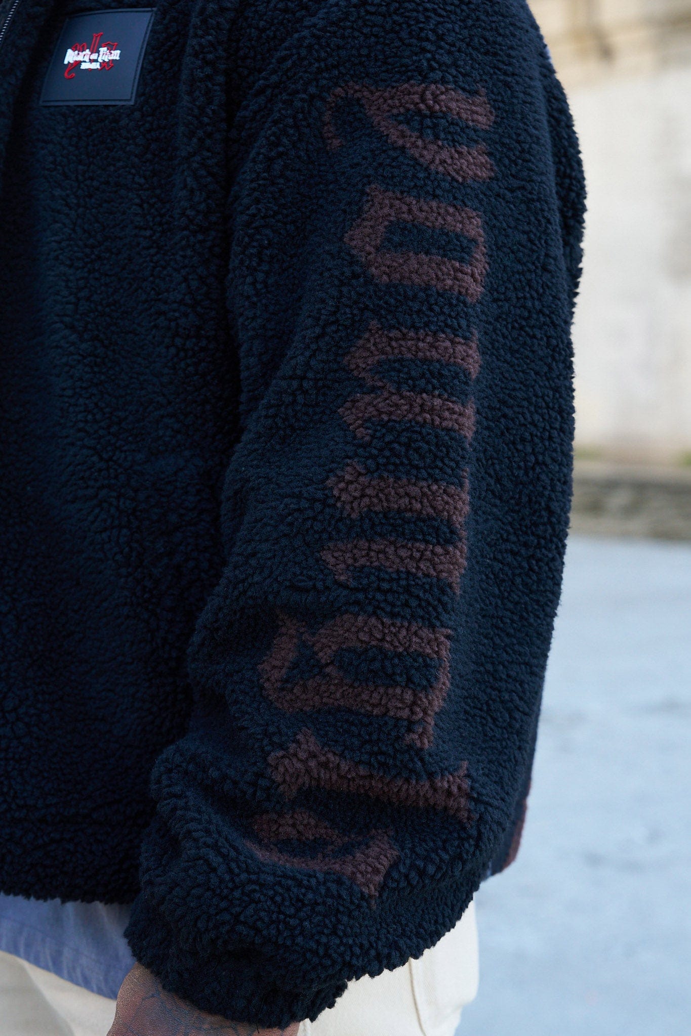 Model wearing the Attack on Titan Sherpa Jacket, showcasing the loose fit and back graphic.