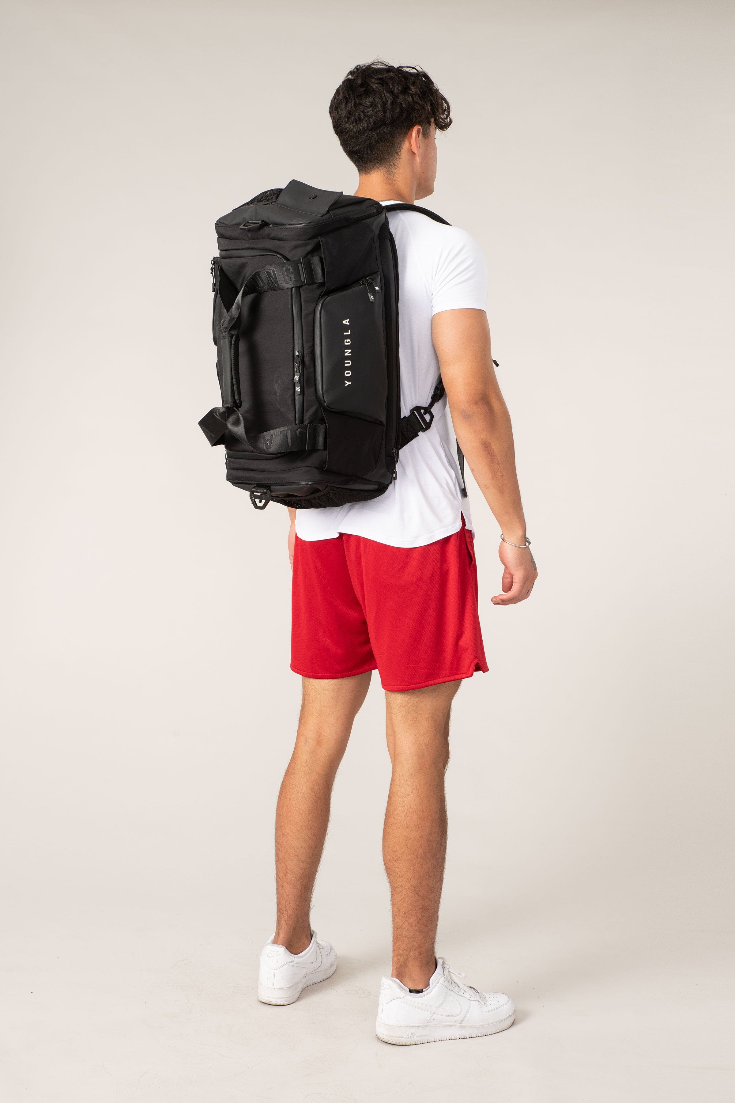 Side view of the backpack duffle bag highlighting the hidden straps and mesh padding.