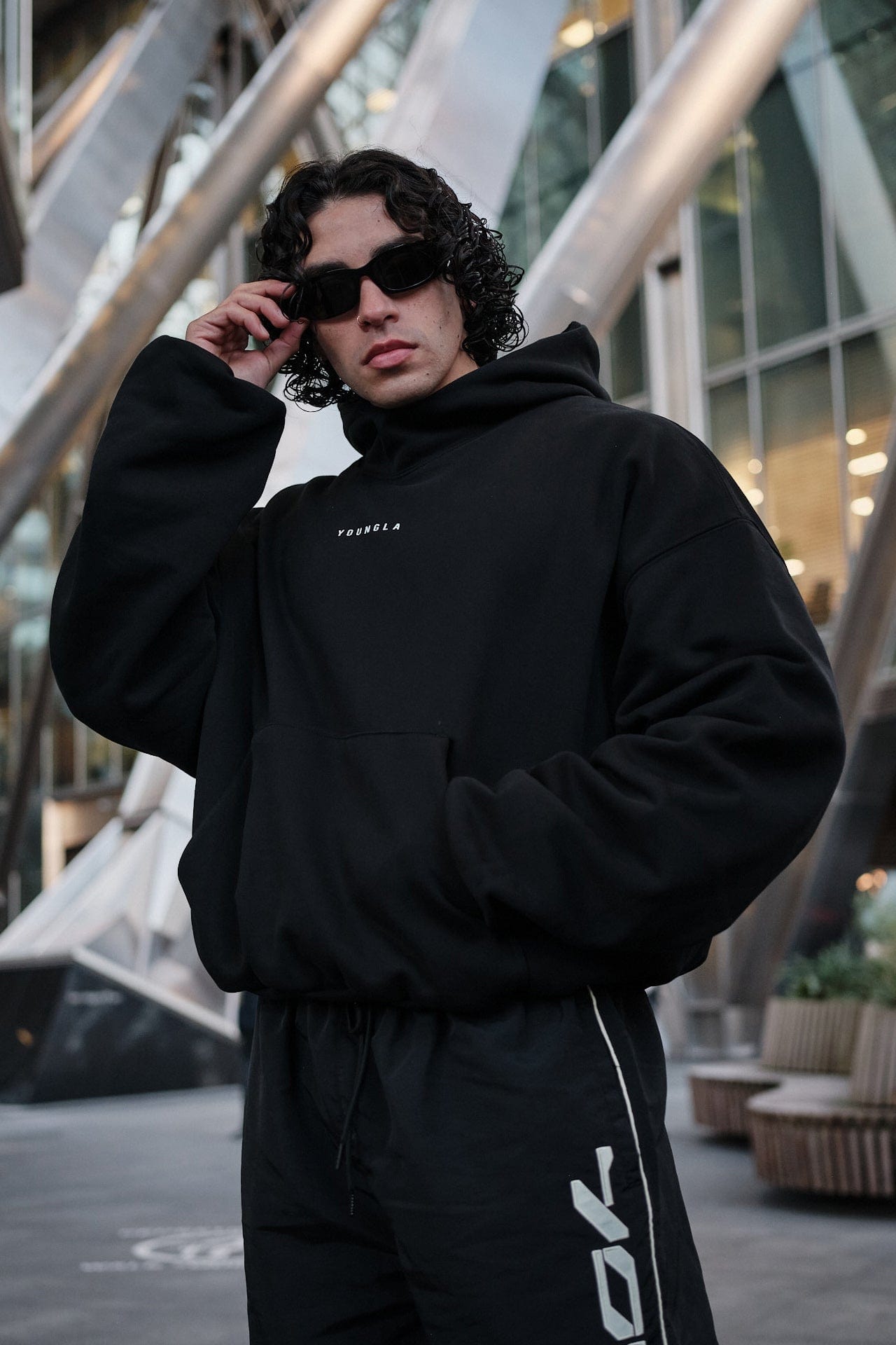 Front view of SphereFit oversized hoodie worn by male model in city backdrop
