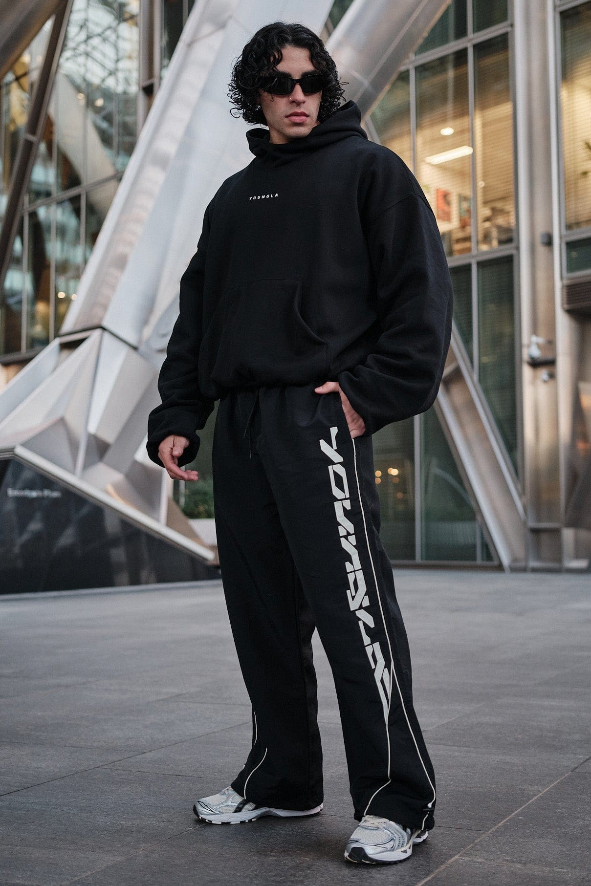 Side view of track pants highlighting the patch logo and lightweight fabric.