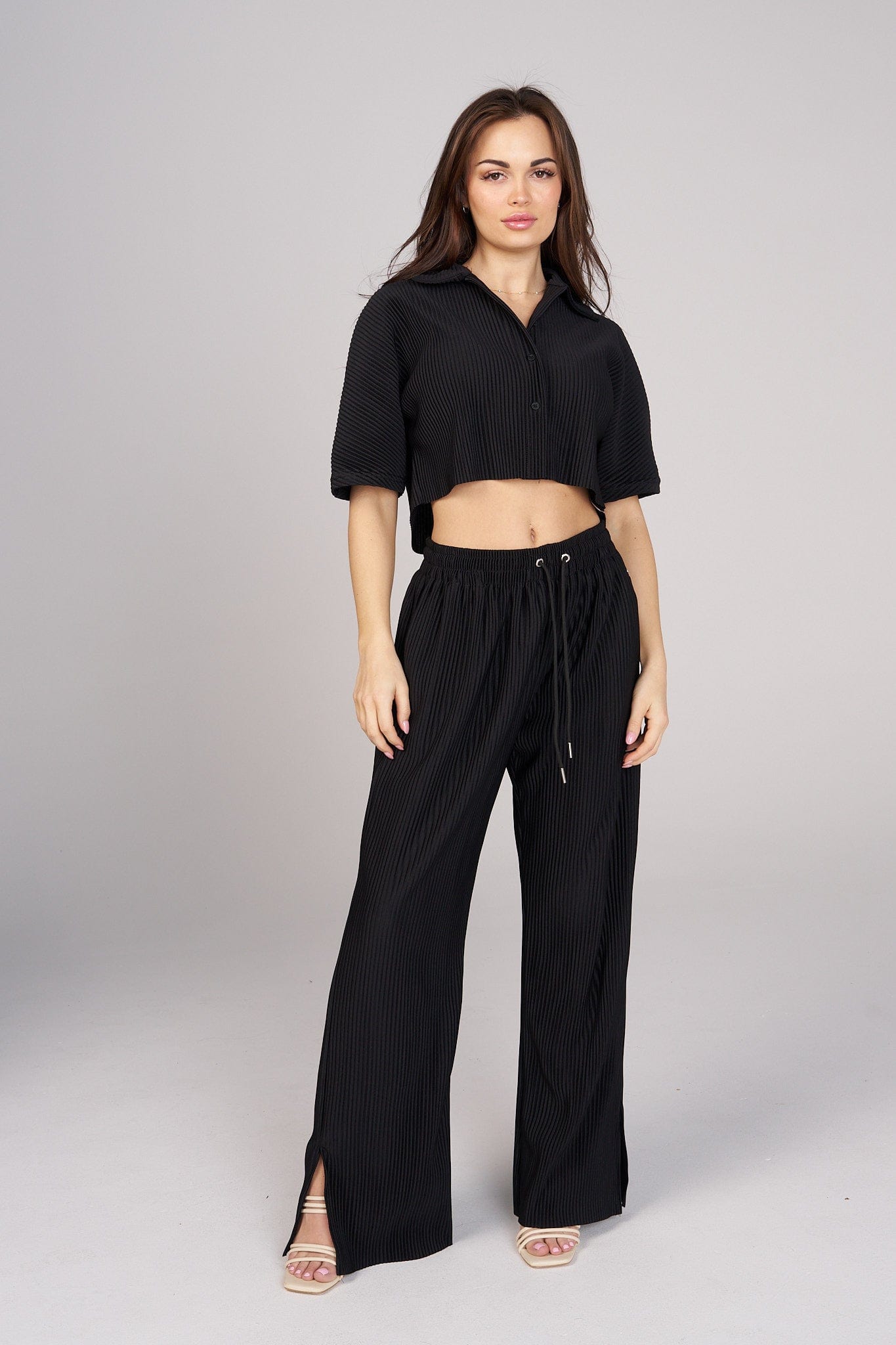 Front view of the Aria elegant pleated top styled for an evening event.