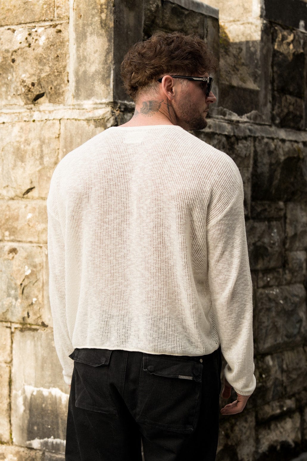 Model wearing the After Dark Crochet Long Sleeve Crop Top in black, styled with jeans.