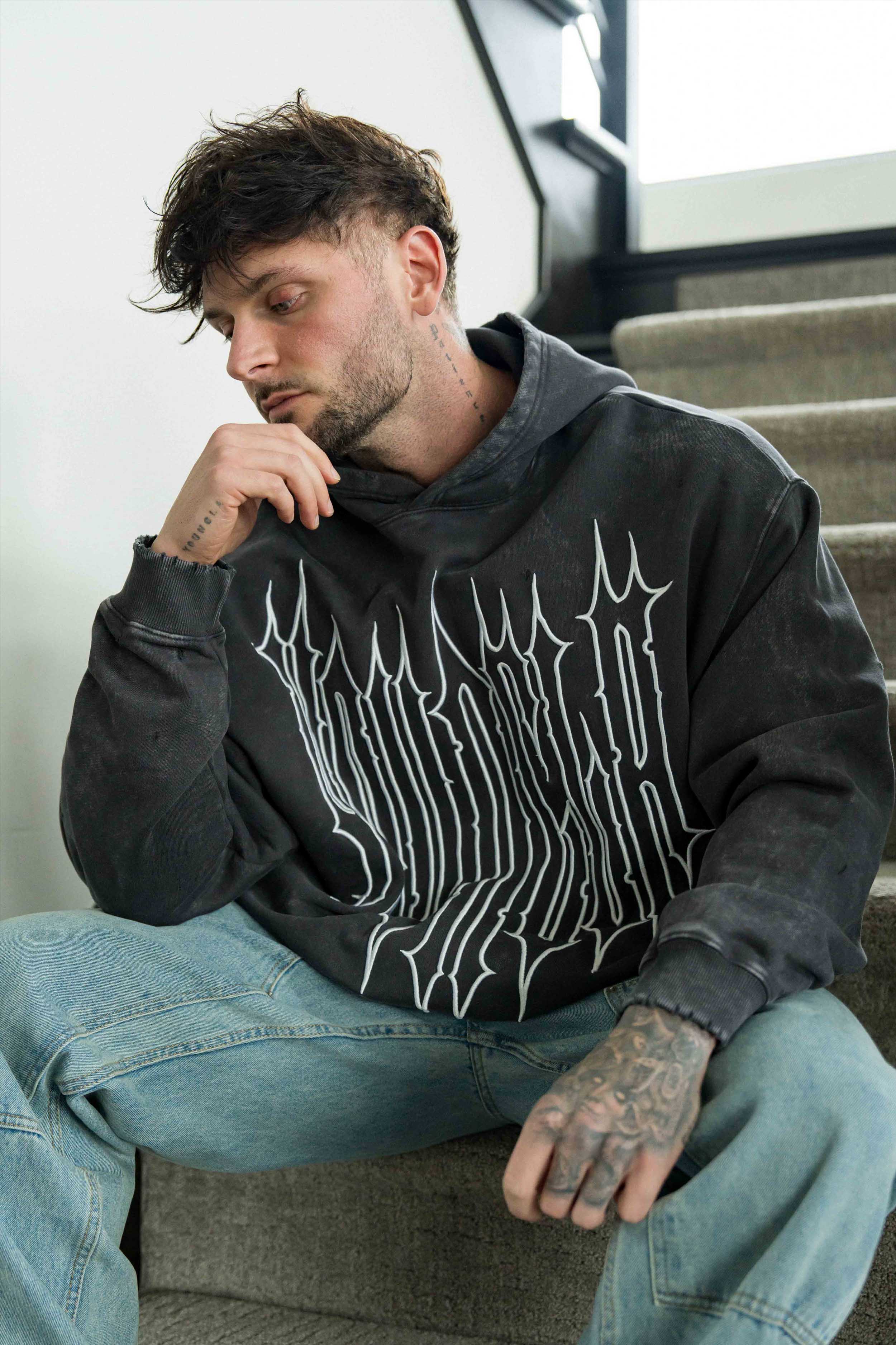 Model in oversized hoodie men’s fit showing cuff and waistband details