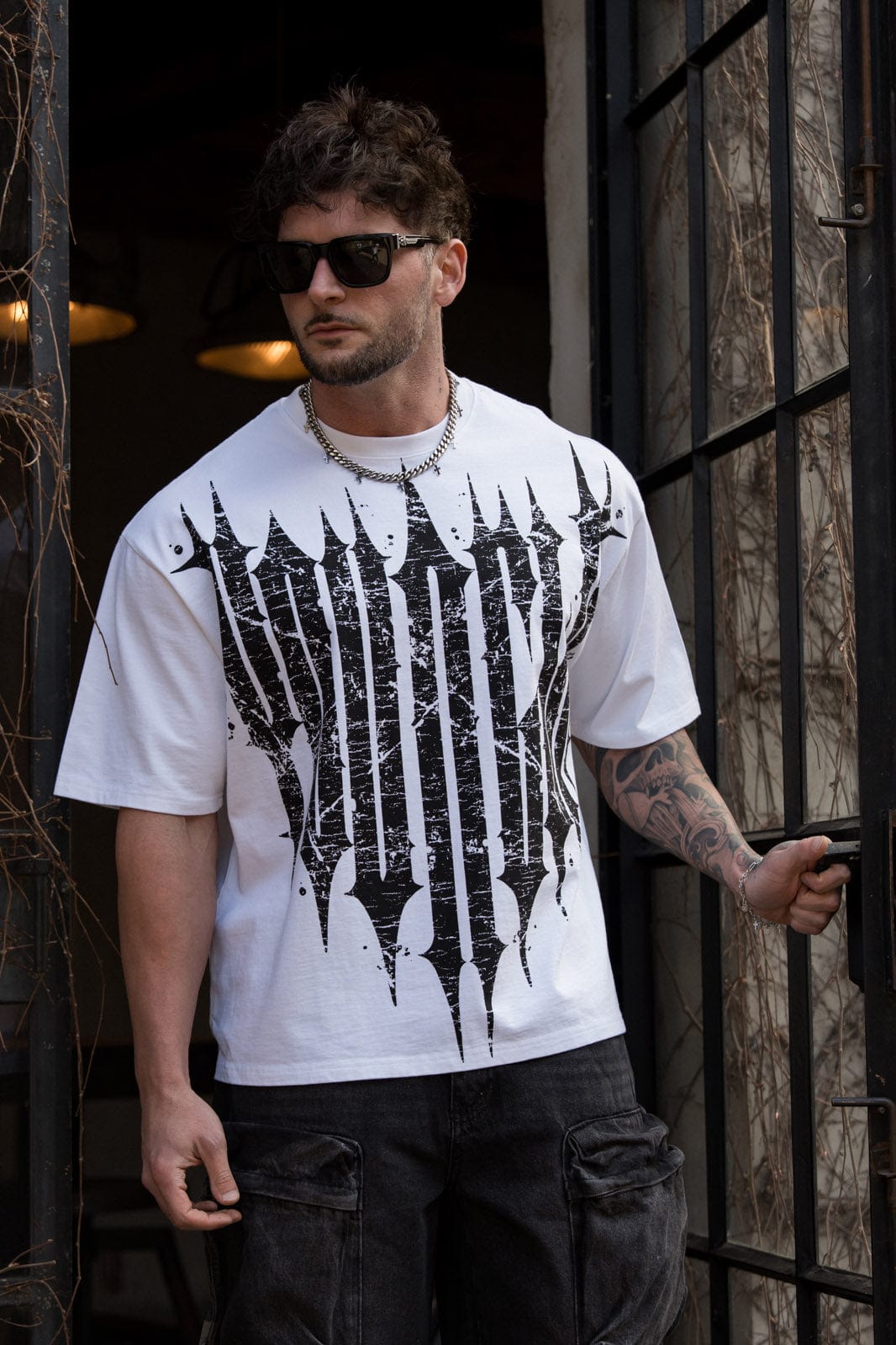 Street-style shot of revenge t-shirt layered under a moto jacket