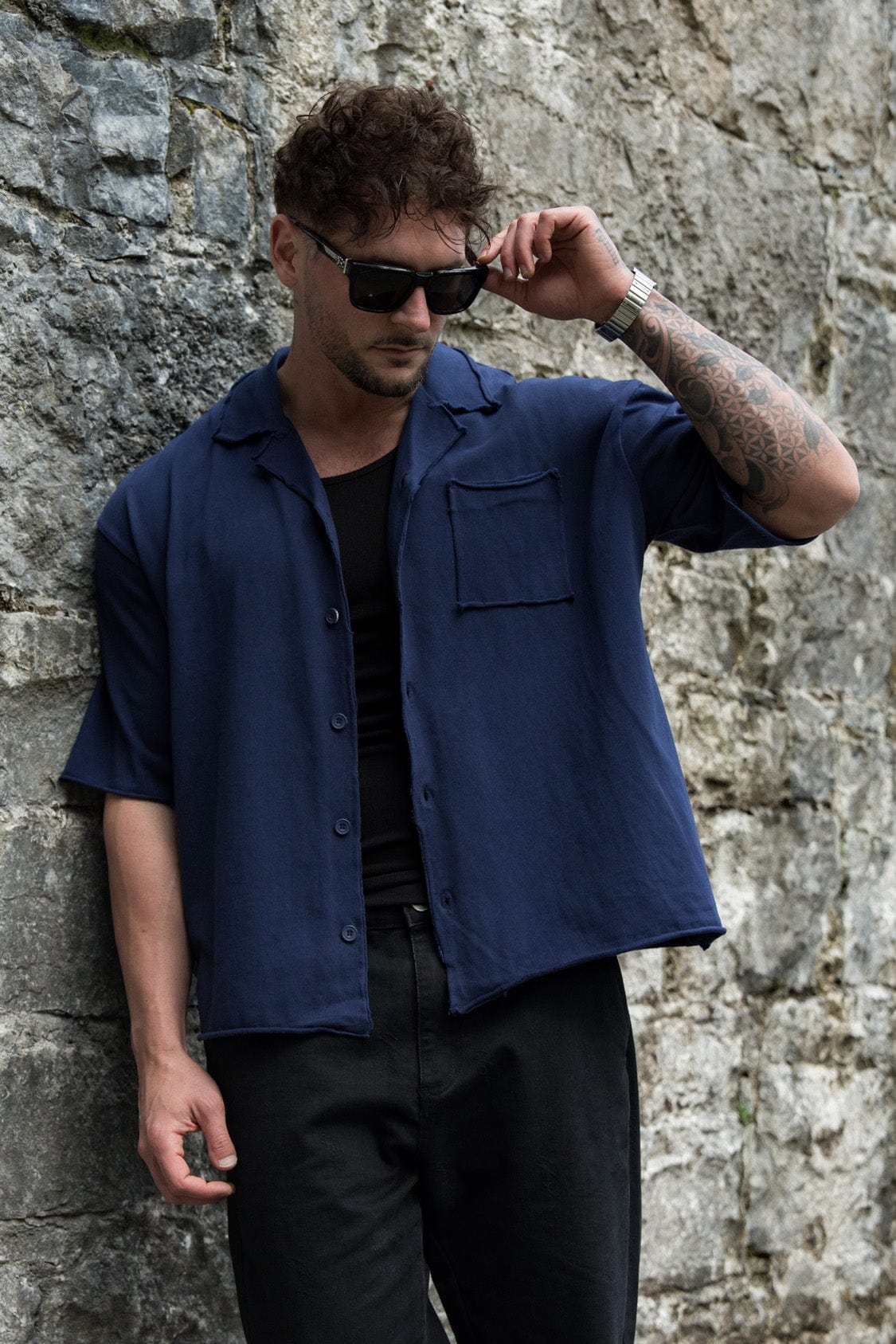 Close-up of the raw cut hems and fabric texture of the oversized button up shirt.