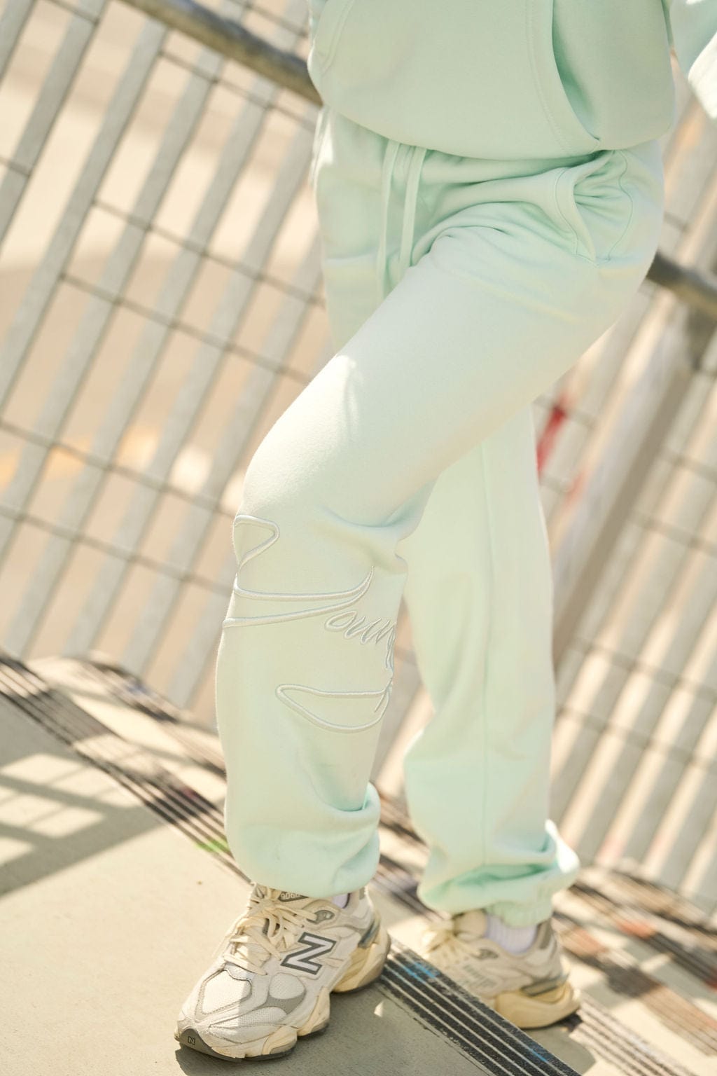 Close-up of fleece joggers with raised embroidery detail.