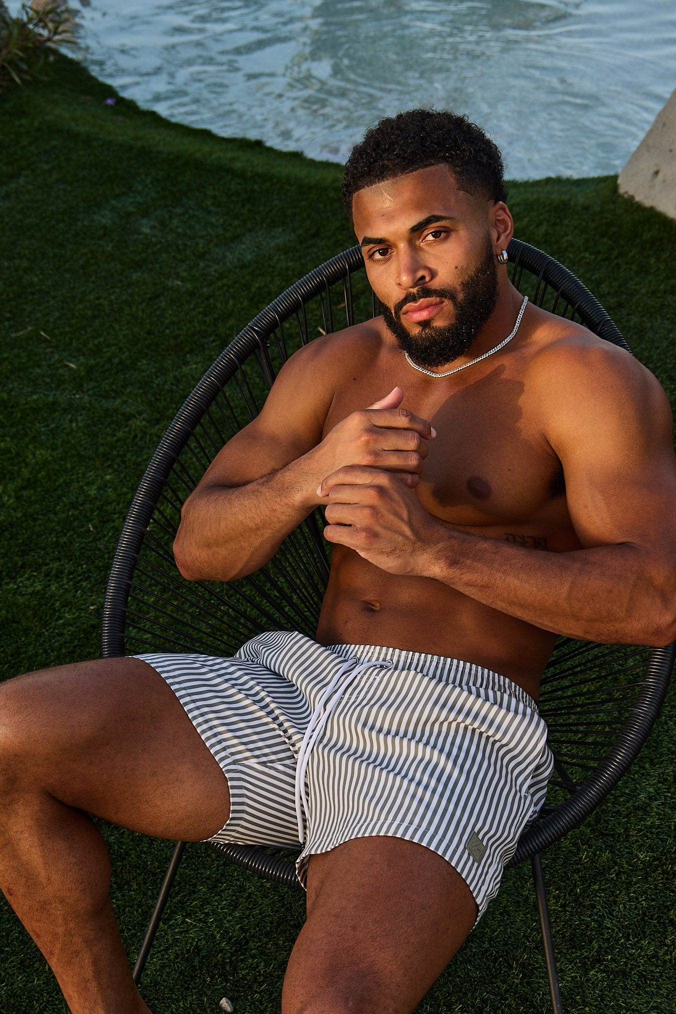 Men wearing striped swim shorts at the poolside, summer style
