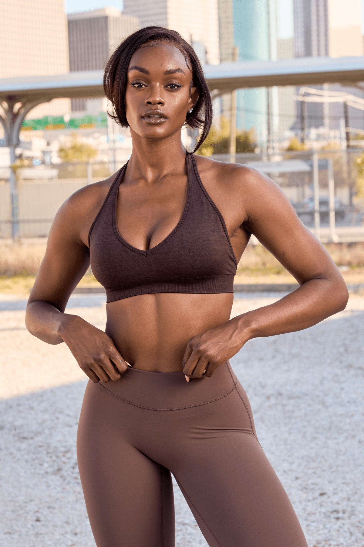 Back view of halter neck sports bra worn with open-back tank top