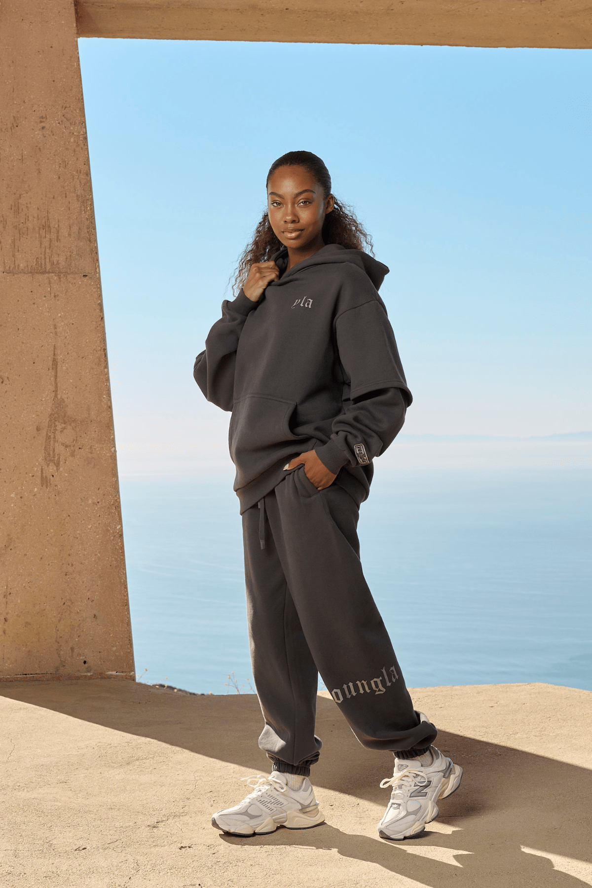 Model wearing joggers for women with a hoodie in a city street setting