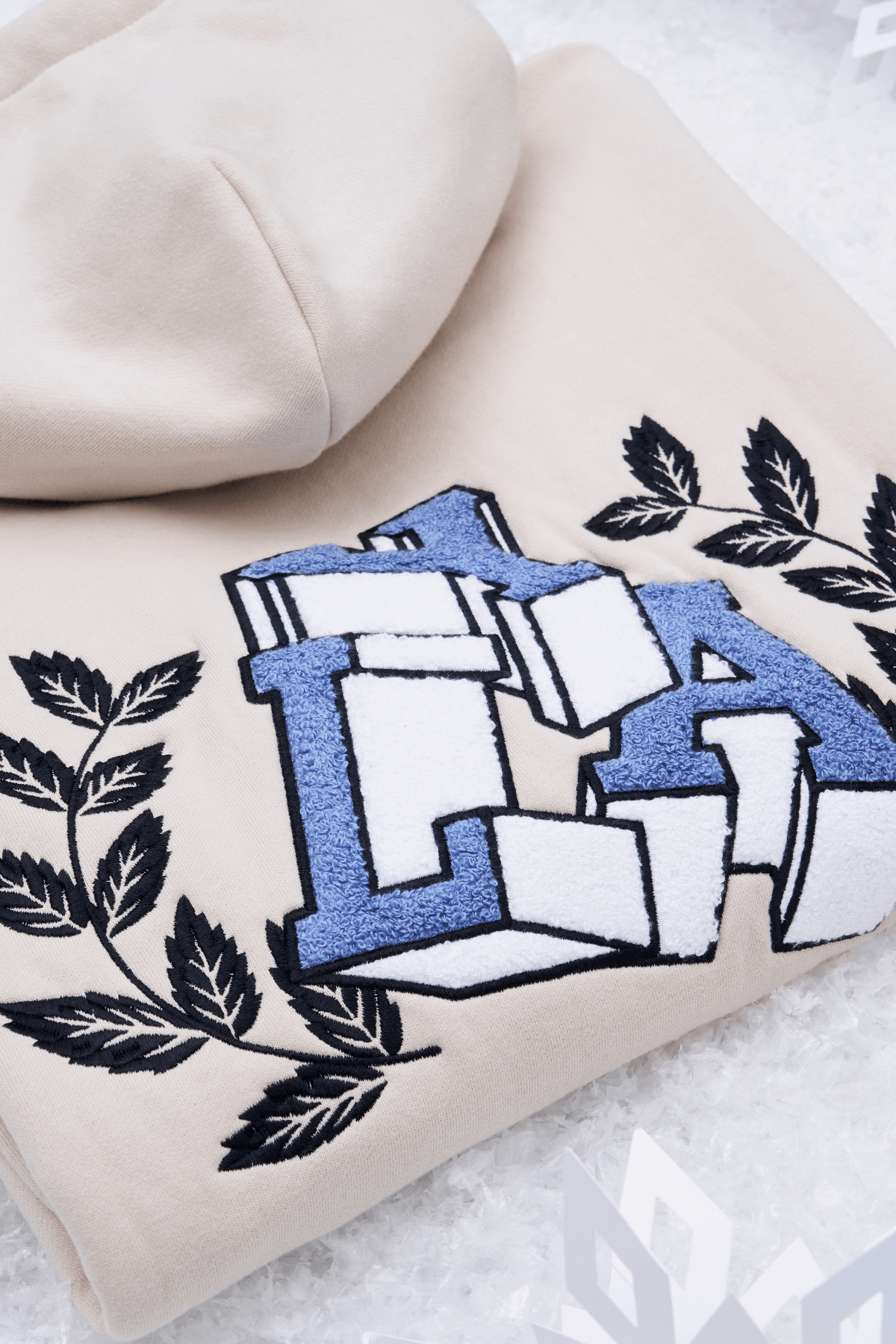 Side view showing the plush chenille patch detail on the hoodie.