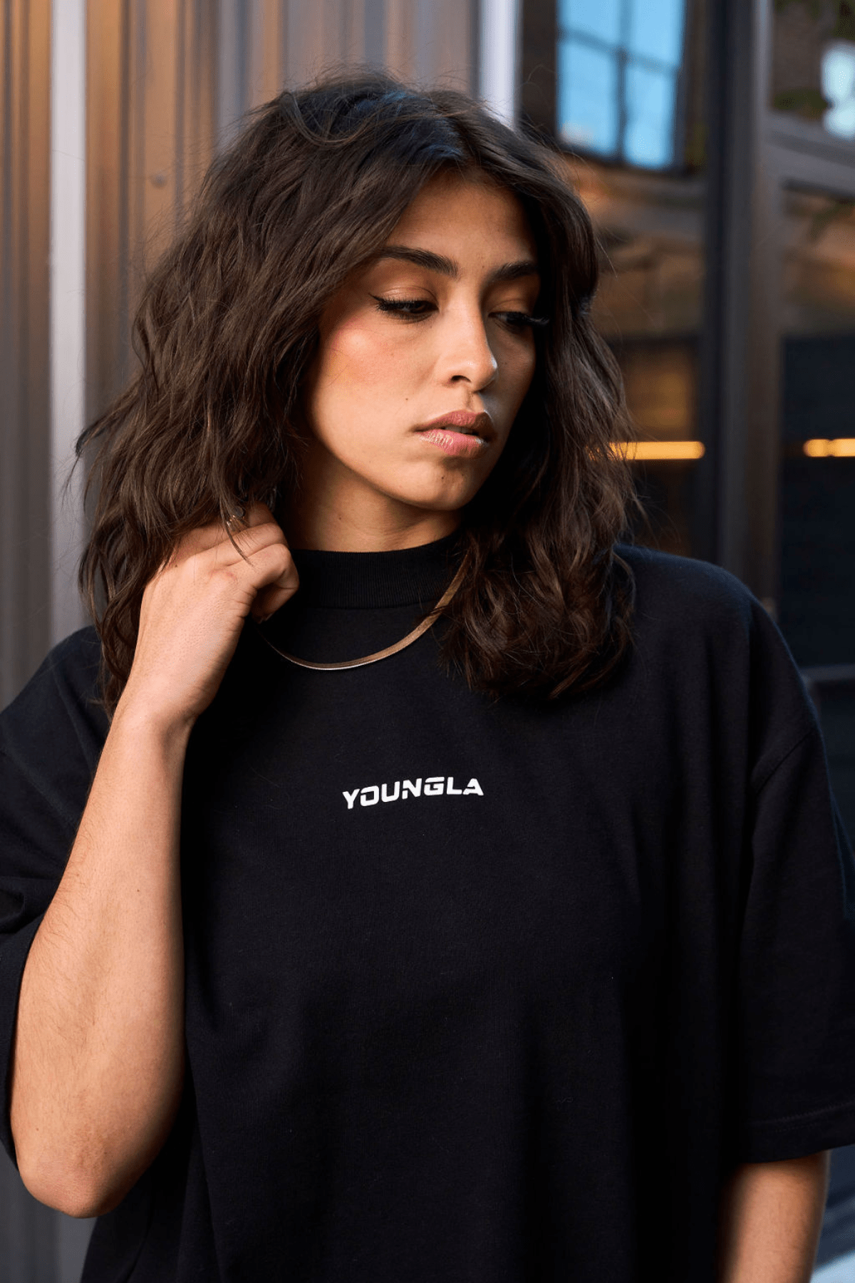 Model wearing oversized graphic tee with digital artwork in a city setting