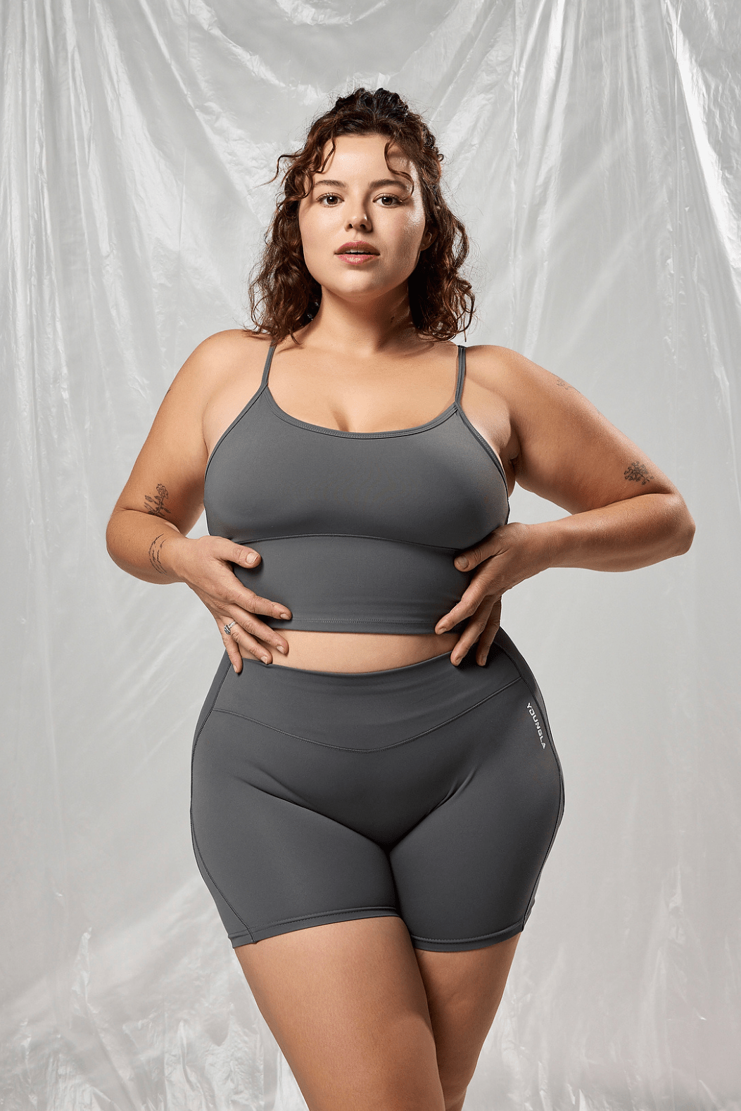 Model showcasing the Sculpted Support Fitness Tank while stretching outdoors.