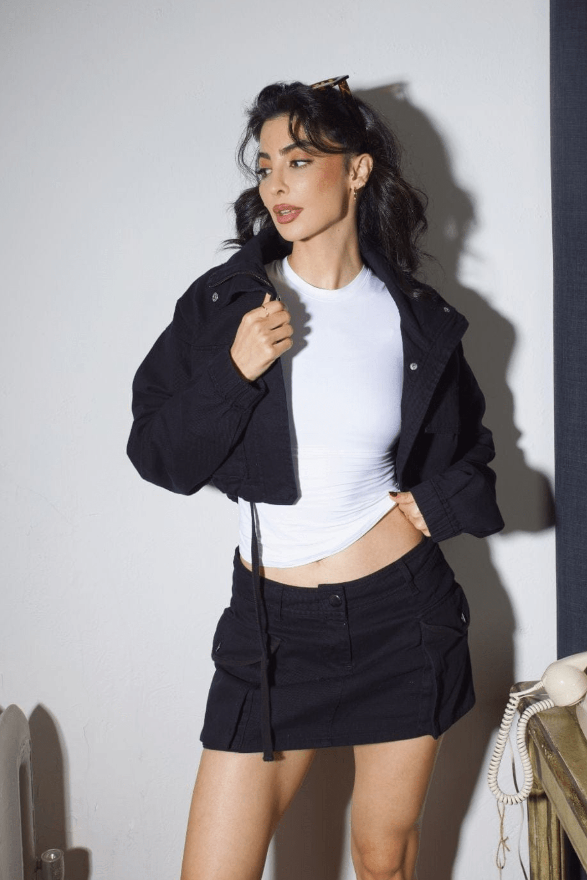 Model wearing the cropped cargo jacket with matching skirt at an outdoor event.