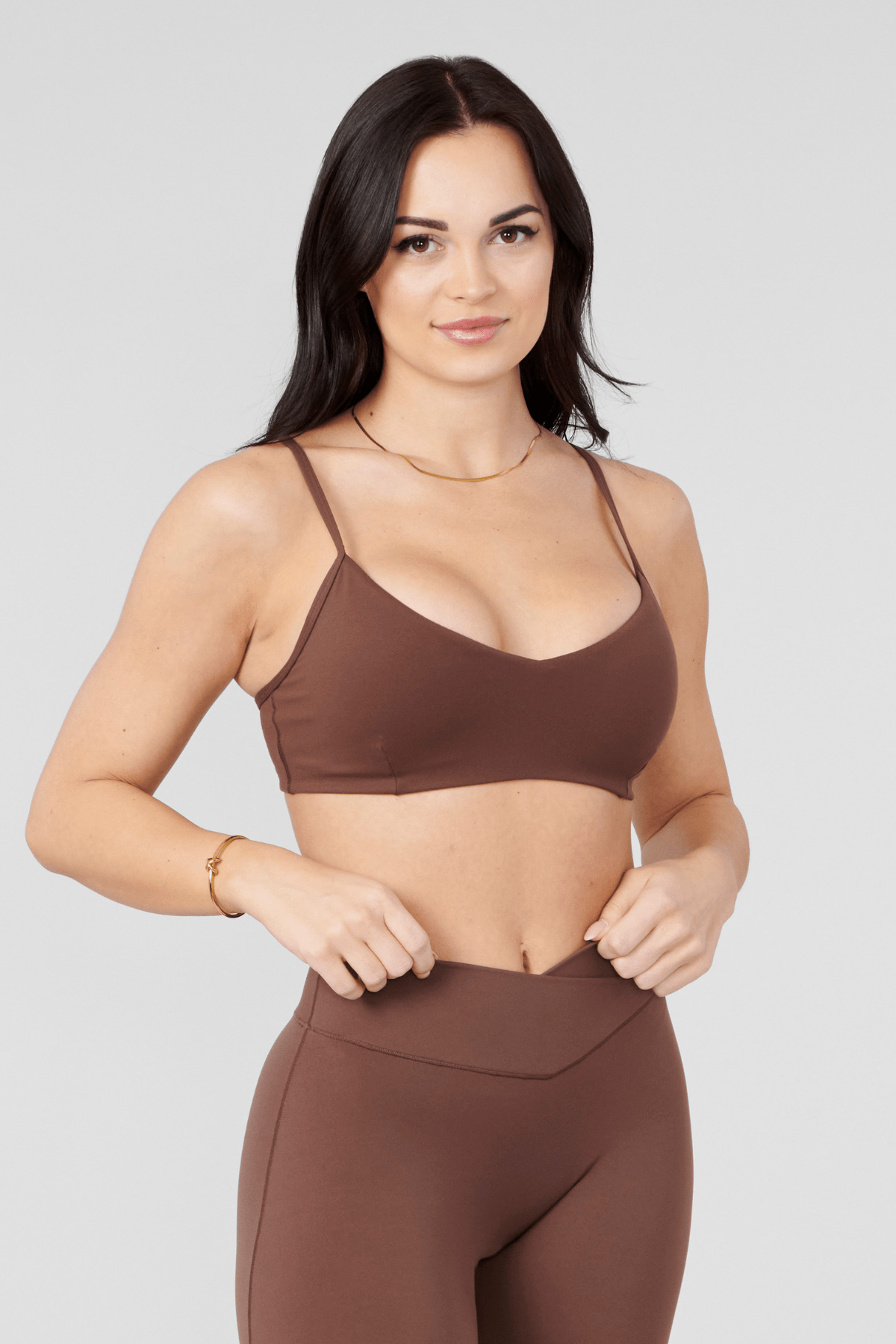 Side view of a model in the Vital Performance Sports Bra paired with Vital Flare leggings.
