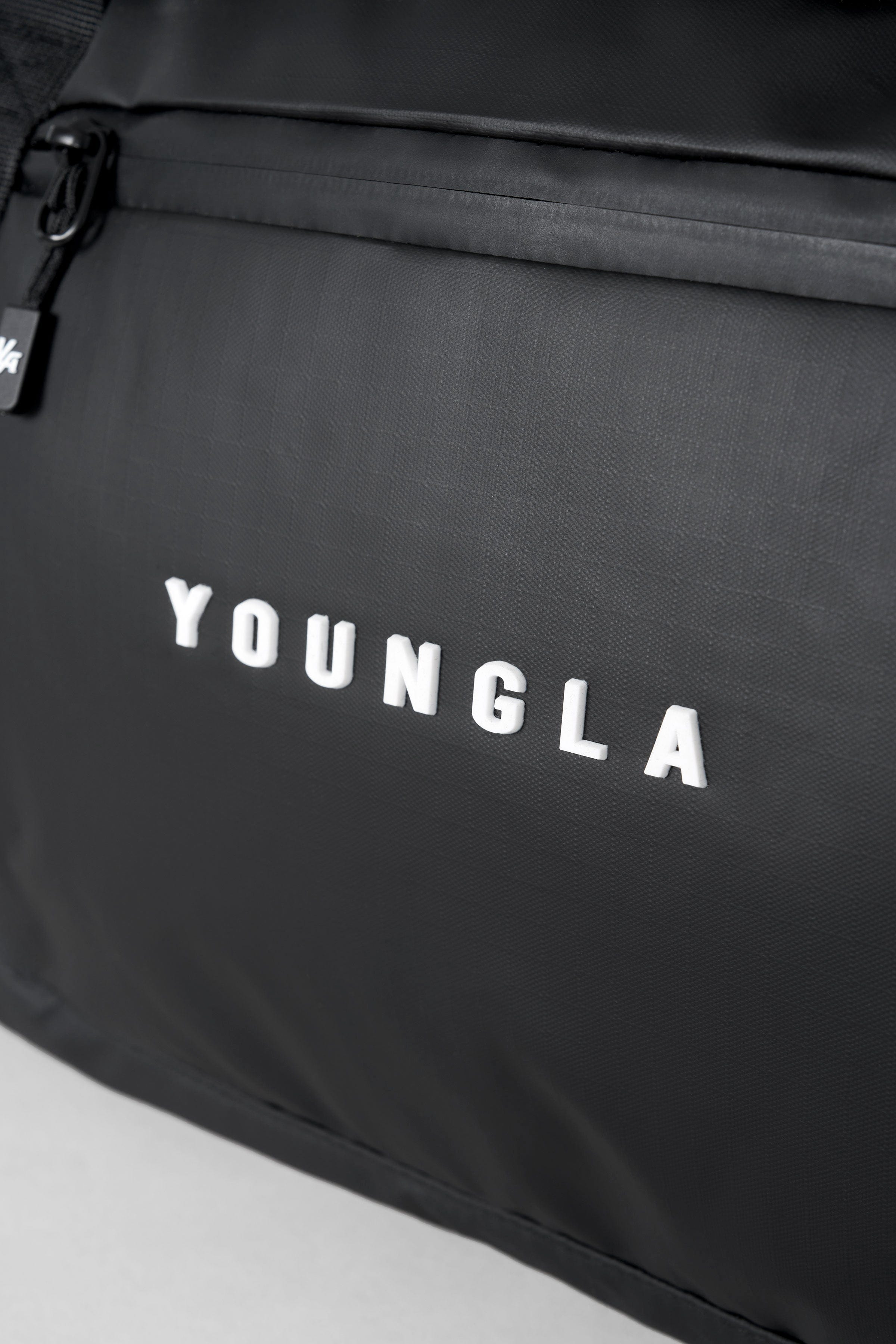 Lifestyle shot of gym duffel bag worn crossbody by a traveler at Phoenix Sky Harbor terminal.