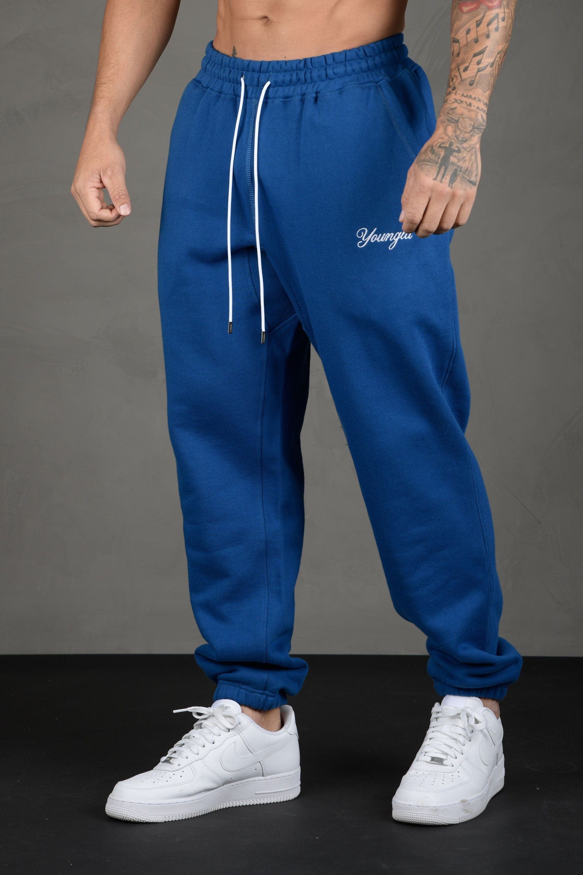 Side profile of model wearing loose-fit joggers in urban setting