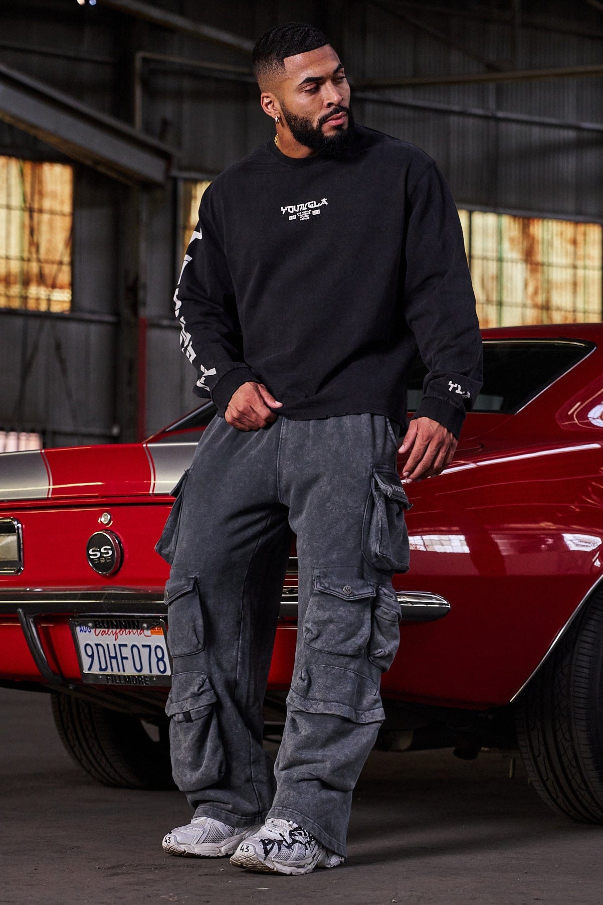 Side angle showing acid-wash detail and baggy fit on black joggers