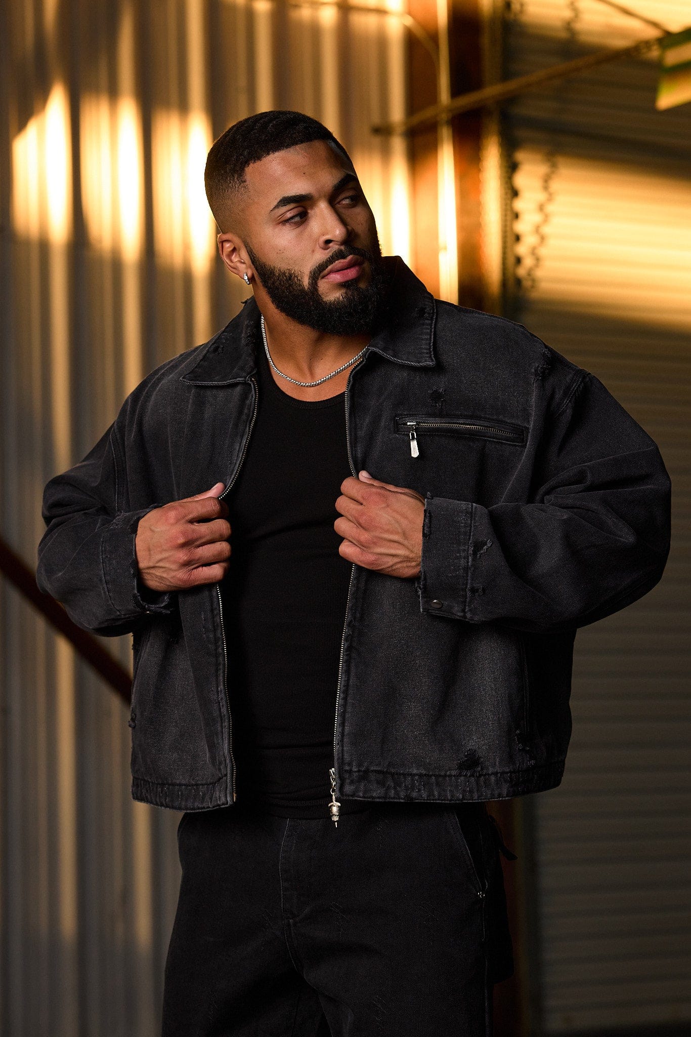 Back angle of jean jacket showing distressed cut and branding details