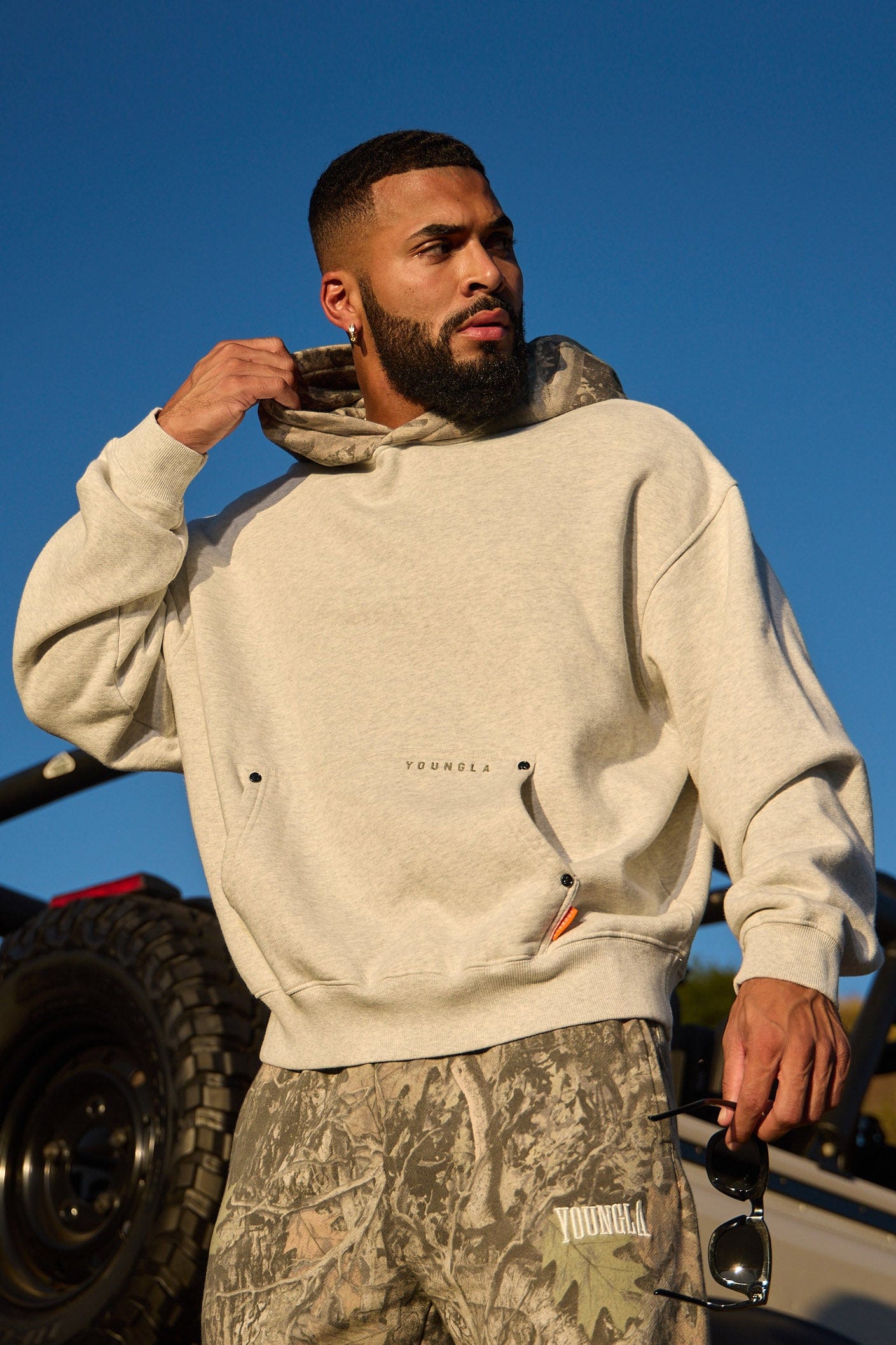 Model wearing the tree camo hoodie outdoors, ideal for fall adventures.
