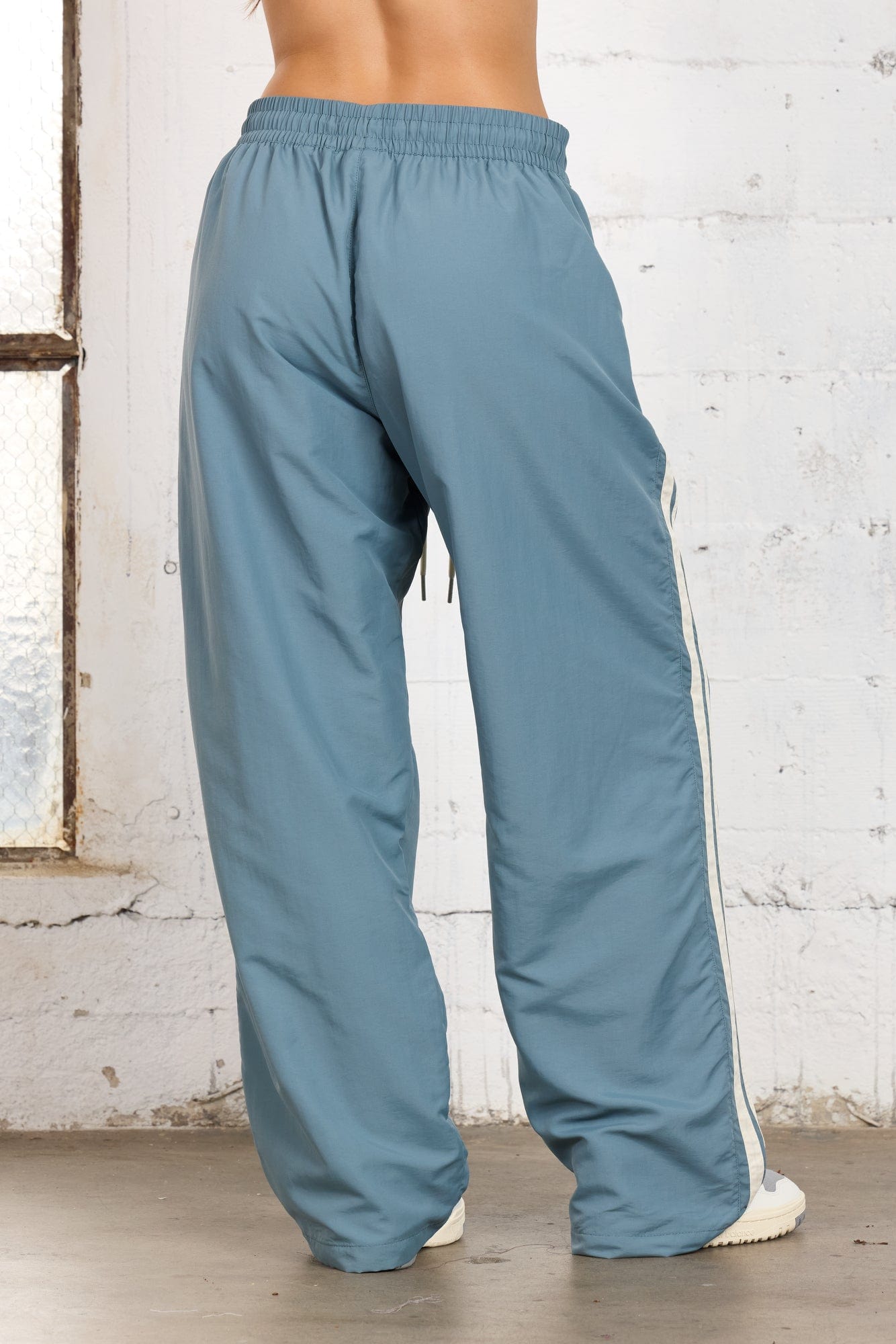Side view showcasing adjustable ankles of athletic pants.