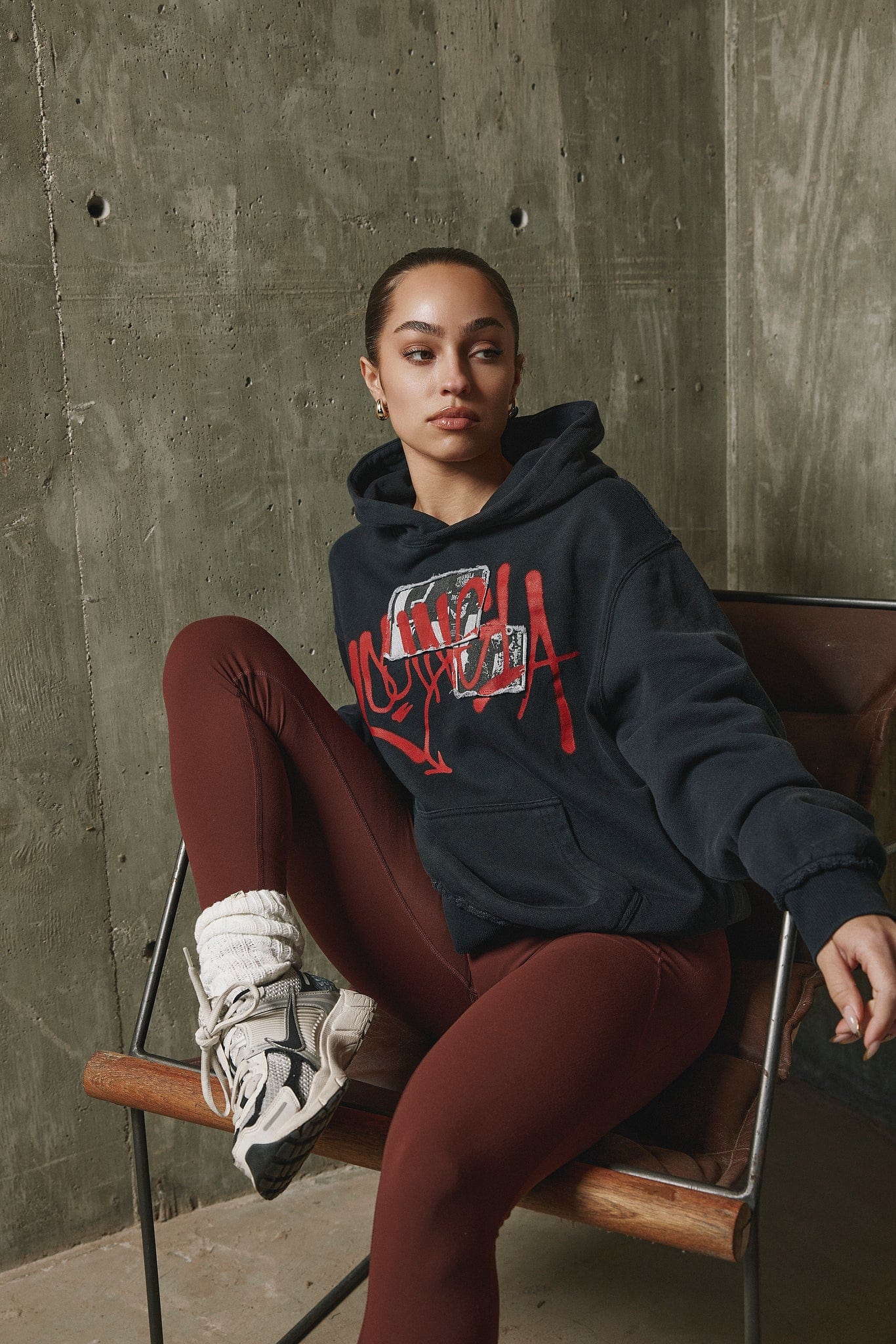 Front view of black graphic hoodie on male model in urban setting