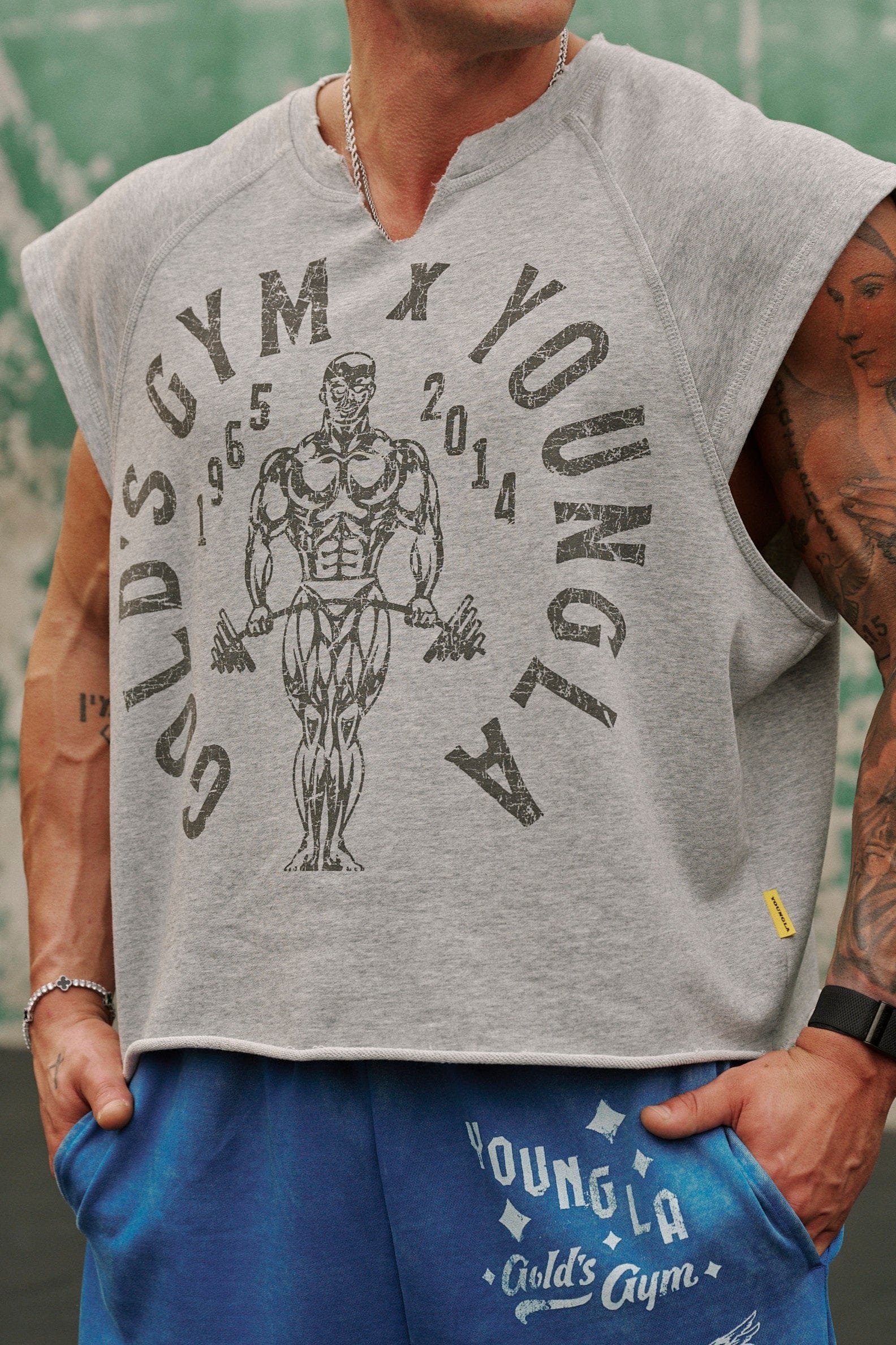 Model wearing Golds Gym vintage cut off shirt during workout.