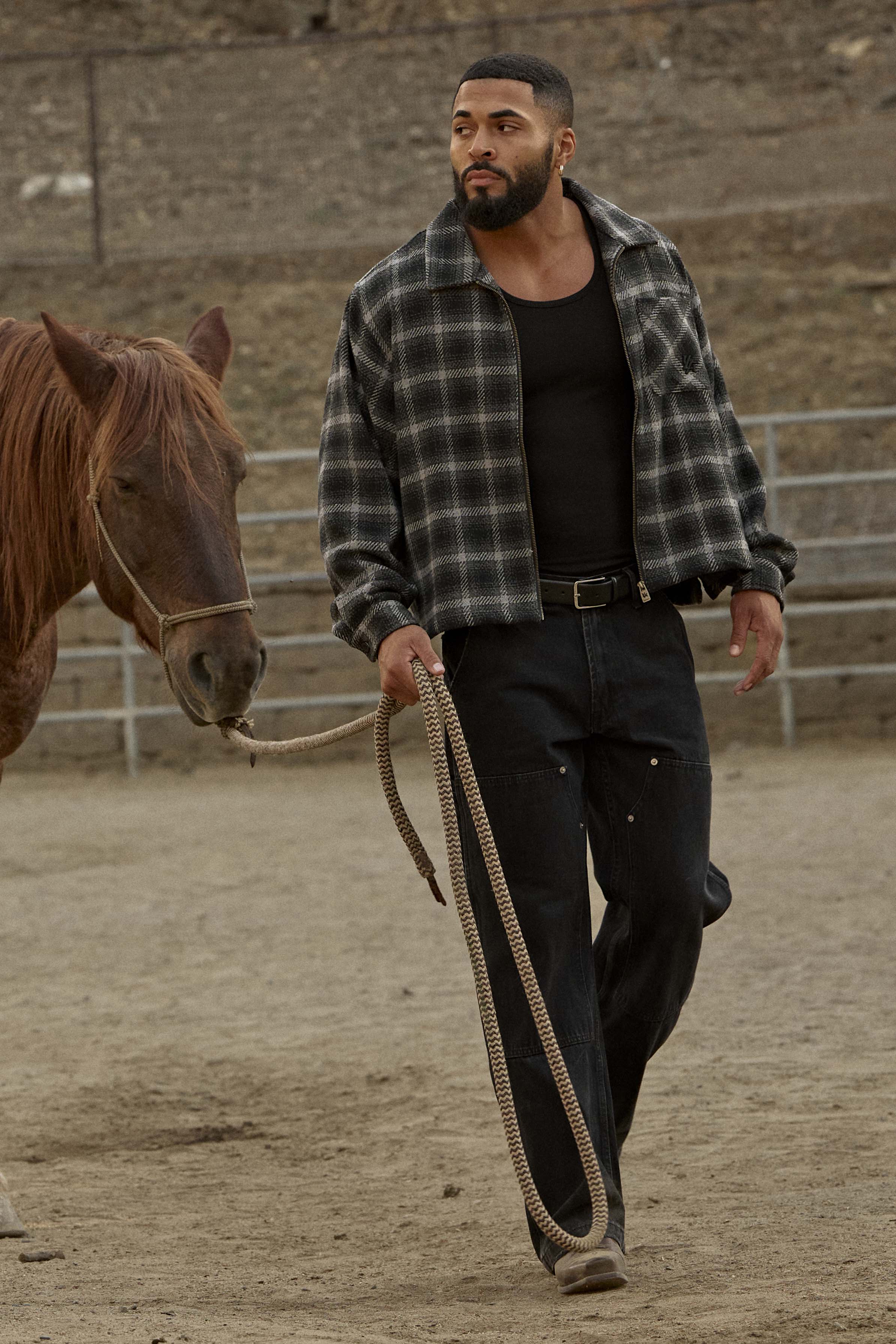 Model wearing the flannel shirt jacket outdoors, hands in pockets.