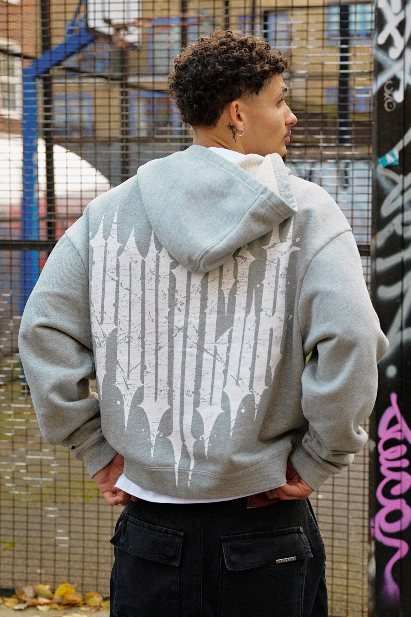 Model wearing the Revenge zip-up hoodie in a streetwear setting, demonstrating its modern style