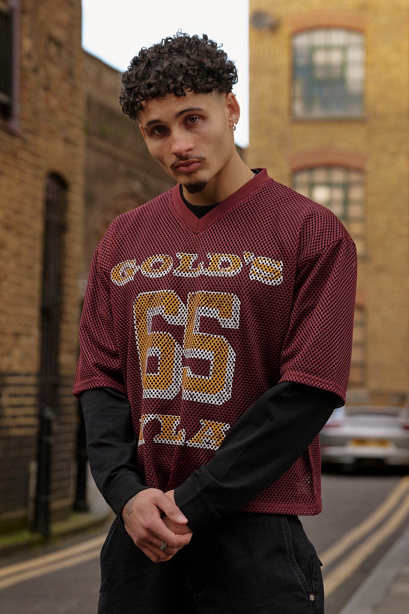Model wearing the Golds Gym x YoungLA Mesh Jersey at the gym, highlighting its stylish design.
