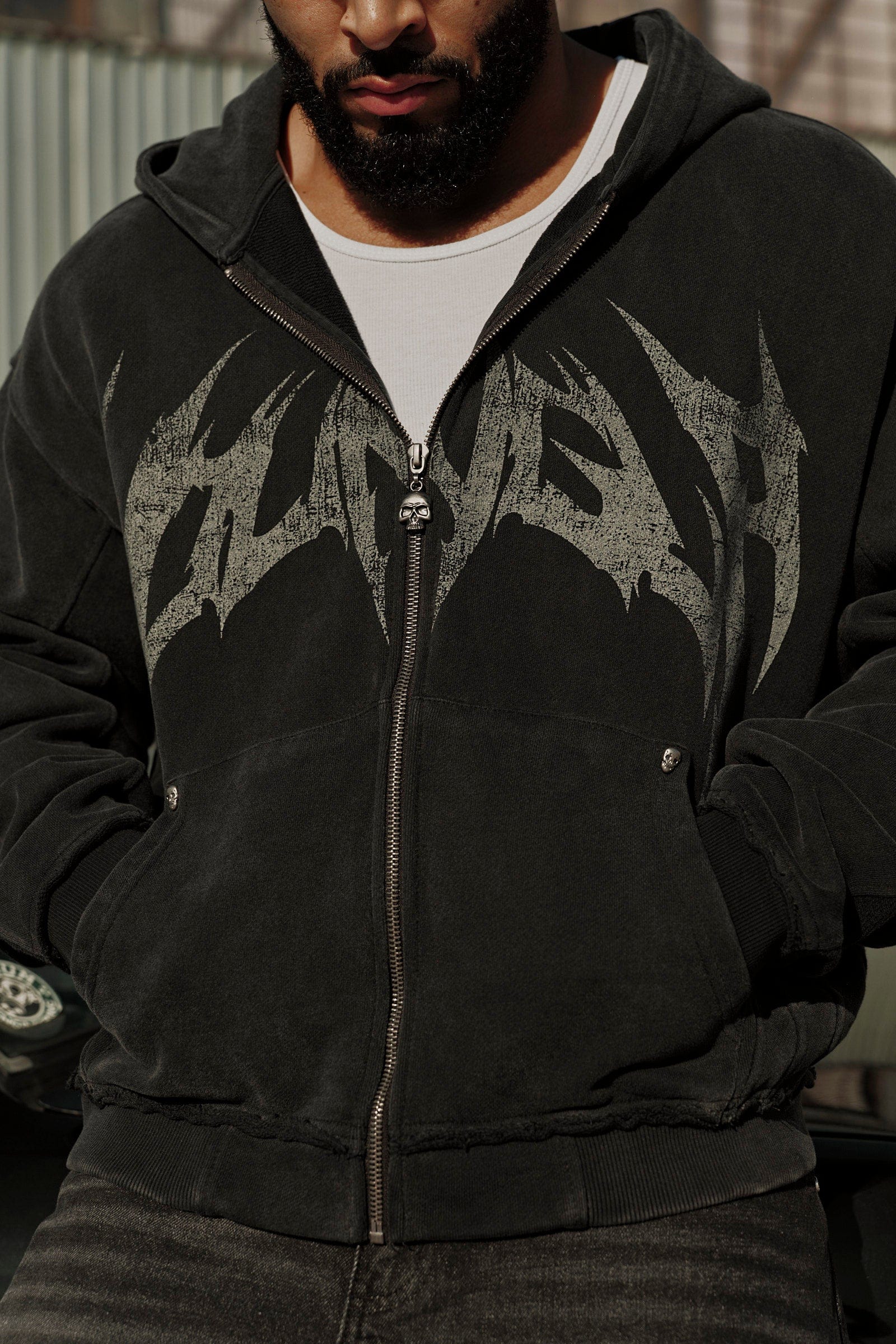 Front view of the distressed black hoodie with skull details.