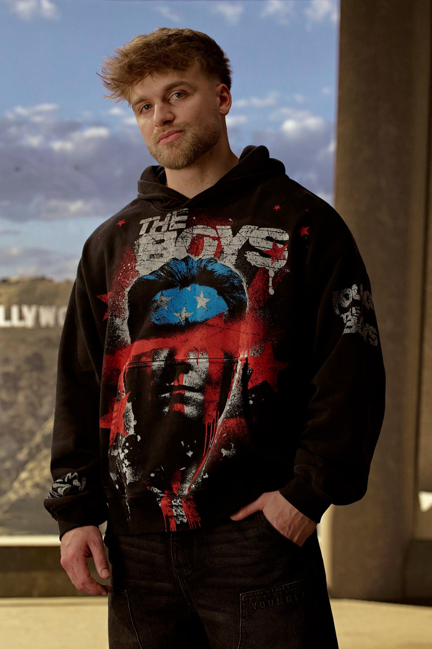 Back view of the mens graphic hoodie in a casual street setting.