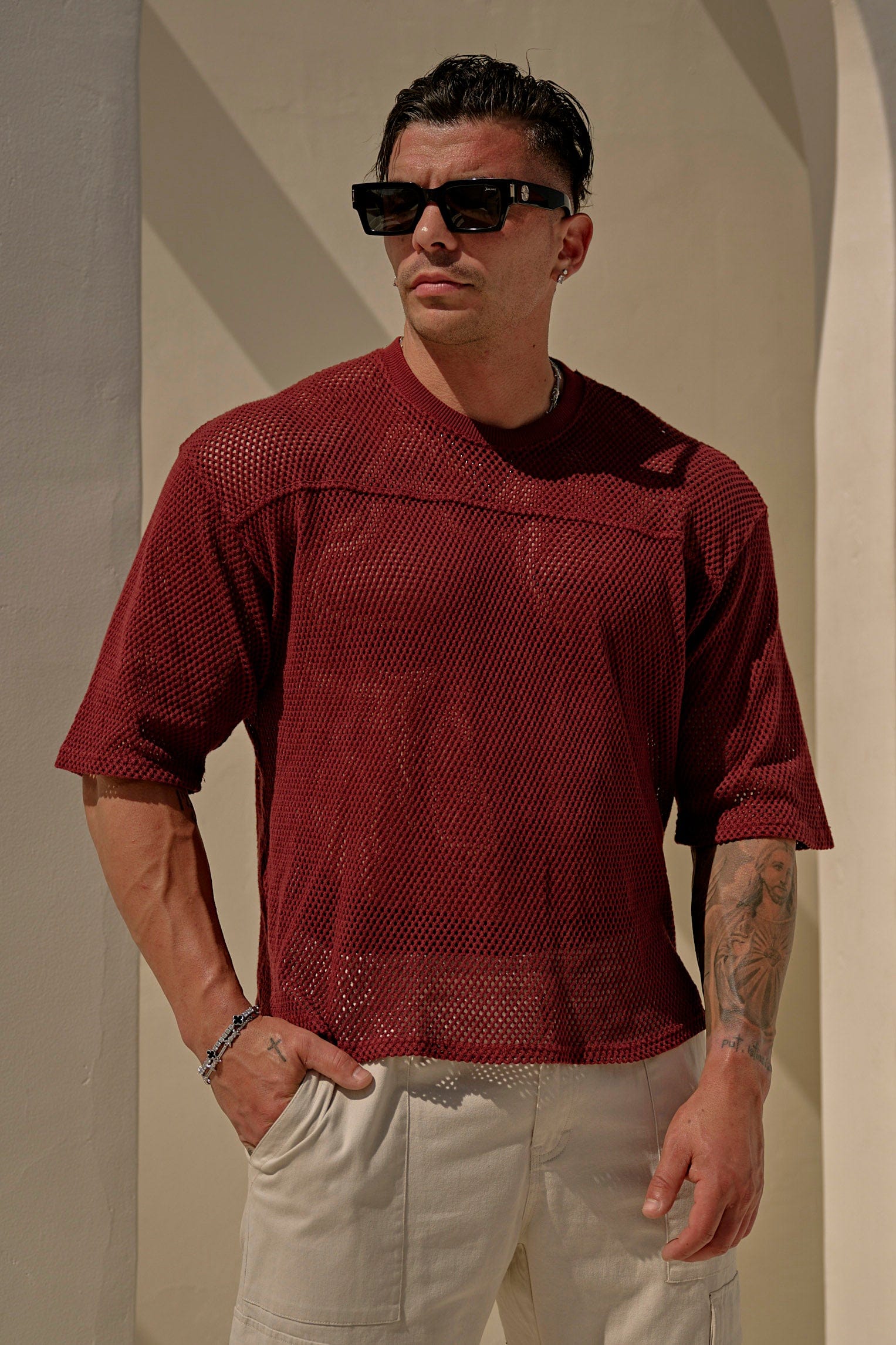 Man wearing an oversized cotton mesh tee with relaxed fit, standing outdoors