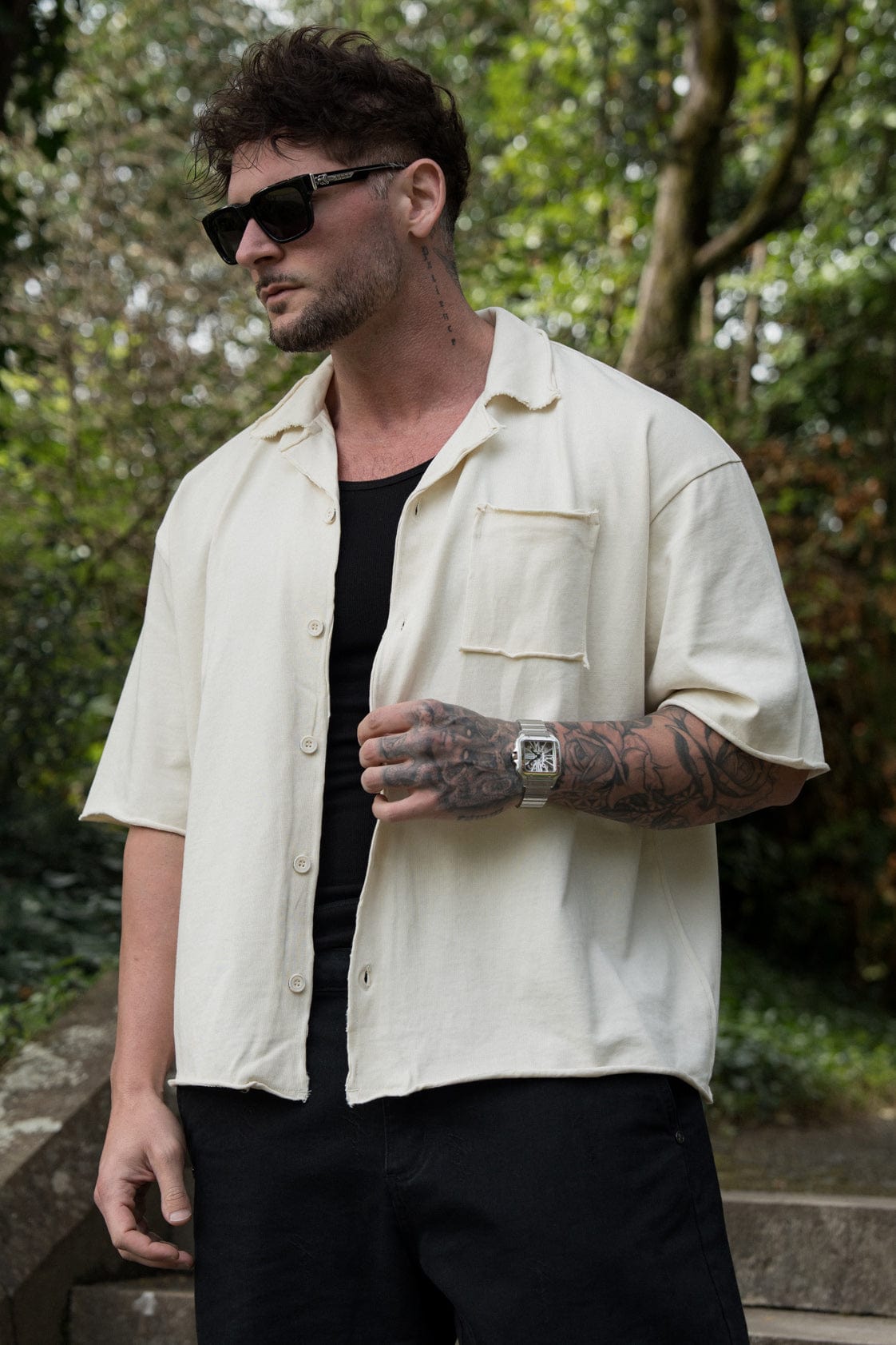 Close-up of the raw cut hems and fabric texture of the oversized button up shirt.