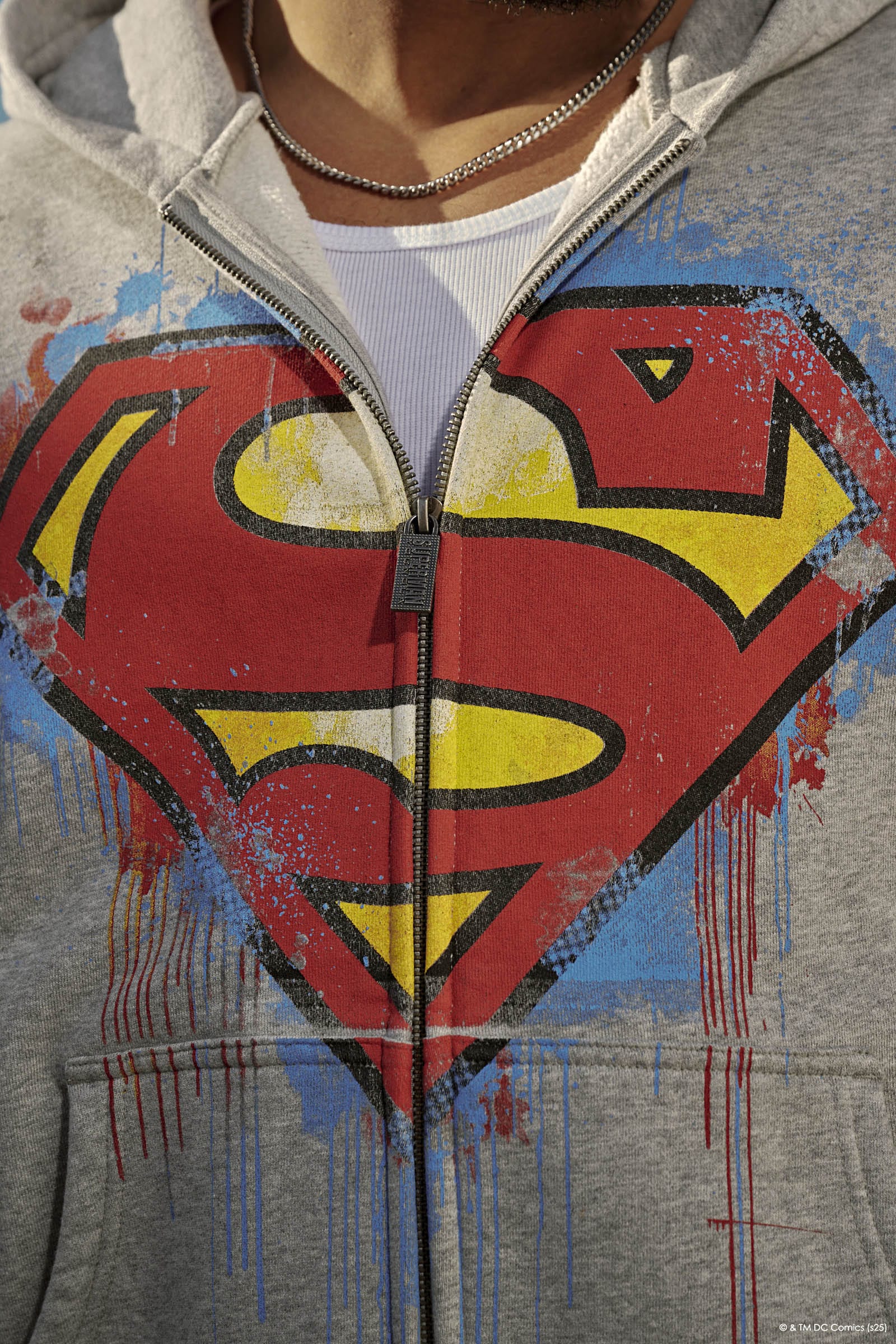 Front view of the Superman camouflage zip-up sweatshirt worn by a model in an urban backdrop.