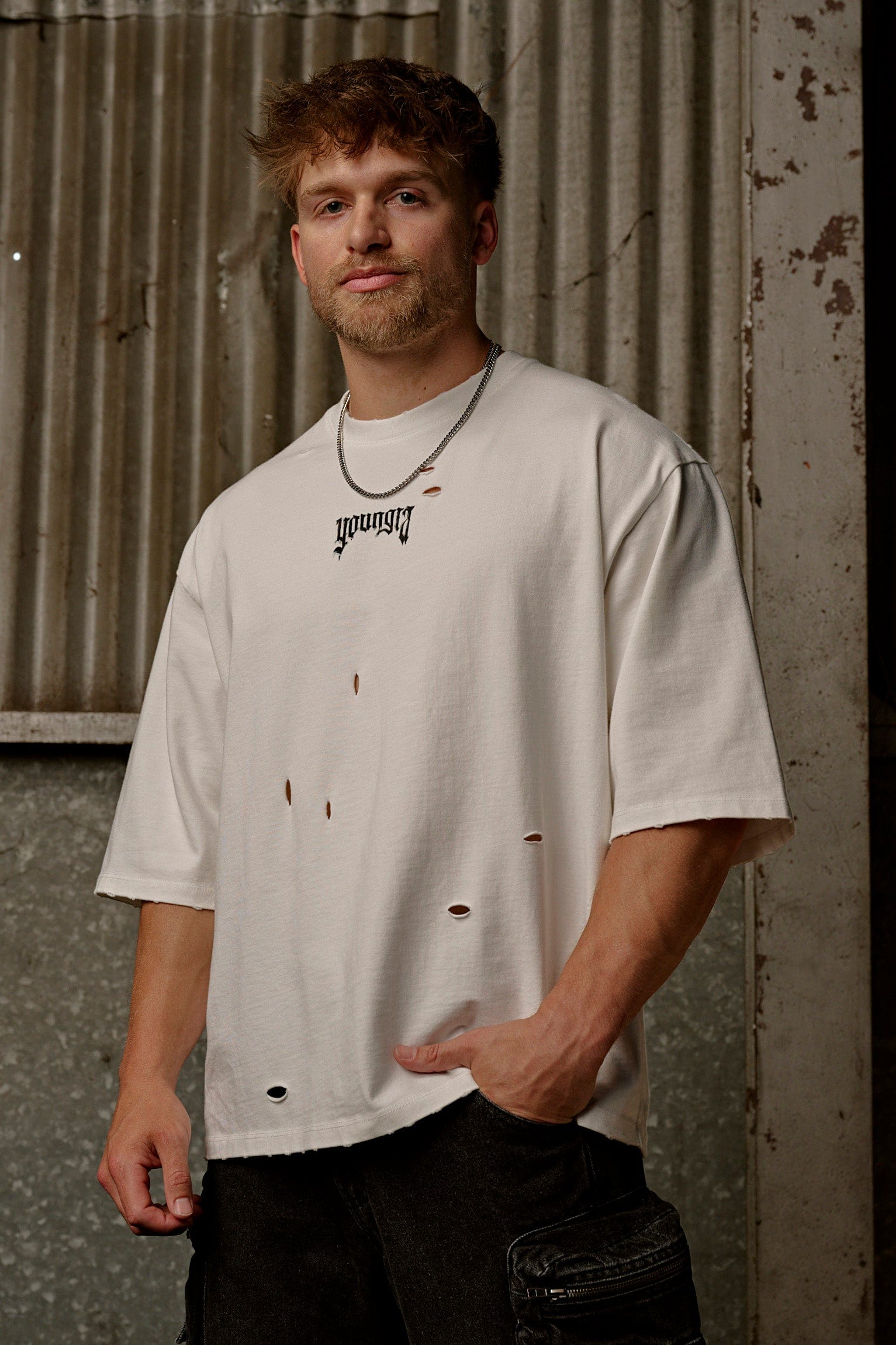Close-up of raw cut holes showcasing distressed tees texture in oversize t shirt