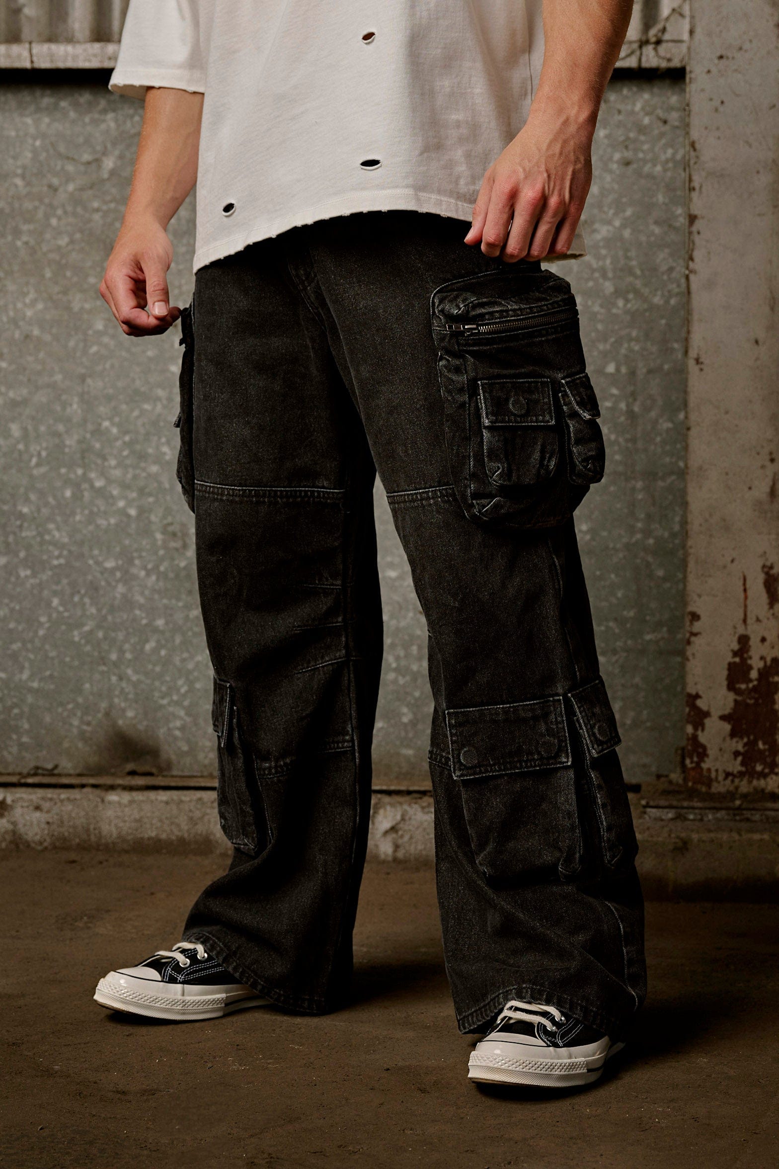 Close-up of the cargo pockets on stylish stacked jeans for men.