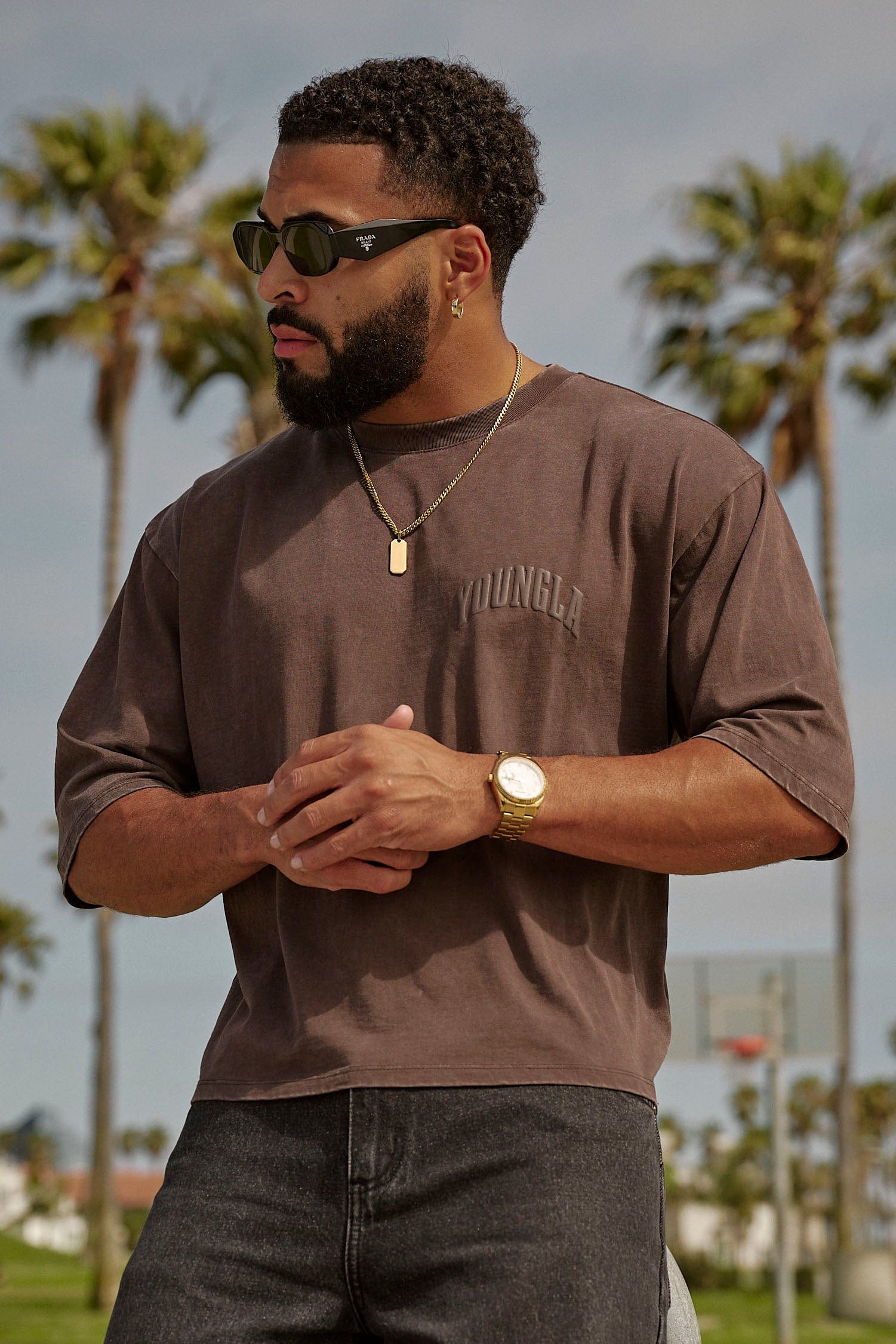 Streetwear model pairing the cropped tee with baggy jeans and sneakers