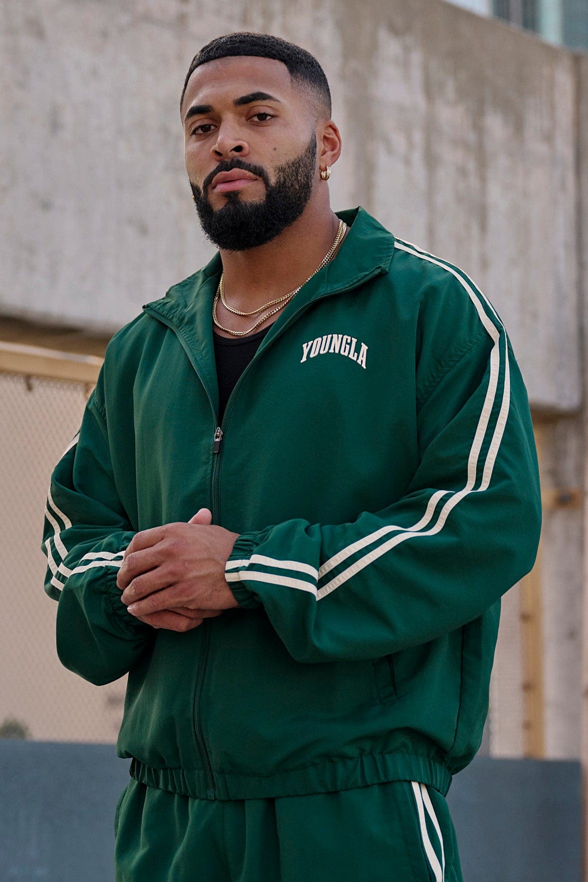 Side view of the black zip-up jacket, highlighting the sleeve stripes.