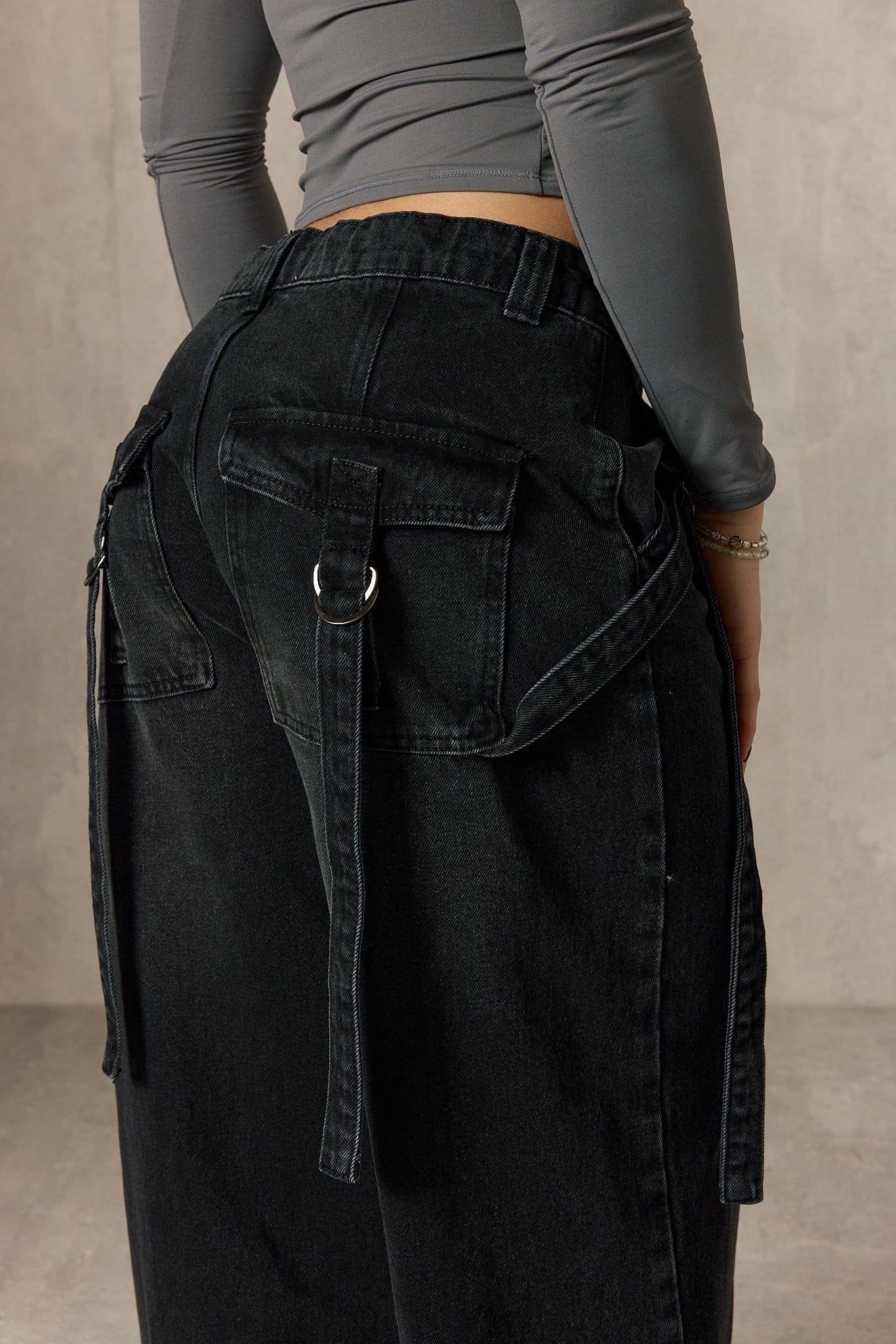Close-up of the jeans fabric highlighting the buckle details.