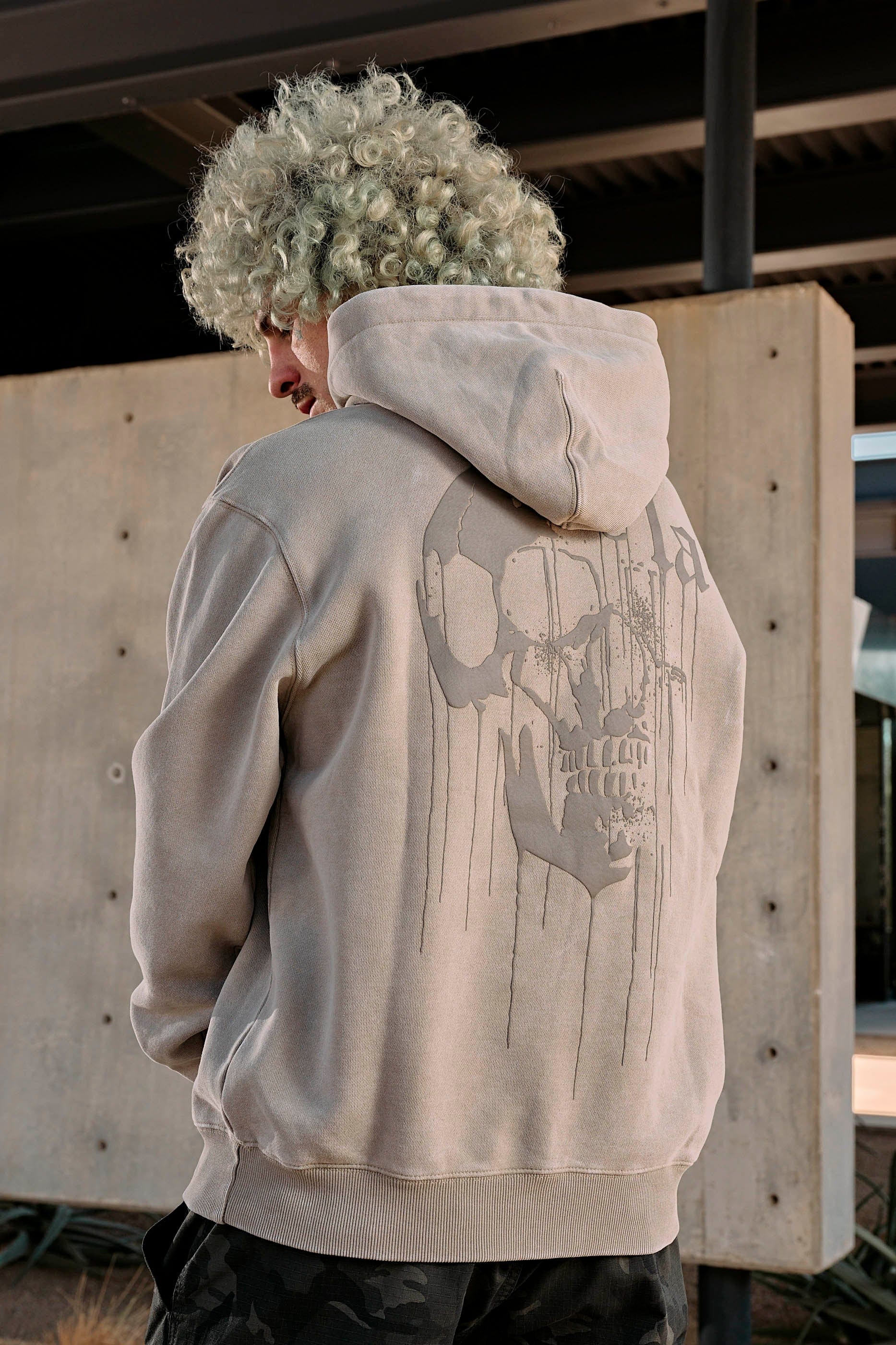 Model wearing the Drippy Skull Hoodie in an urban setting, perfect for street style.
