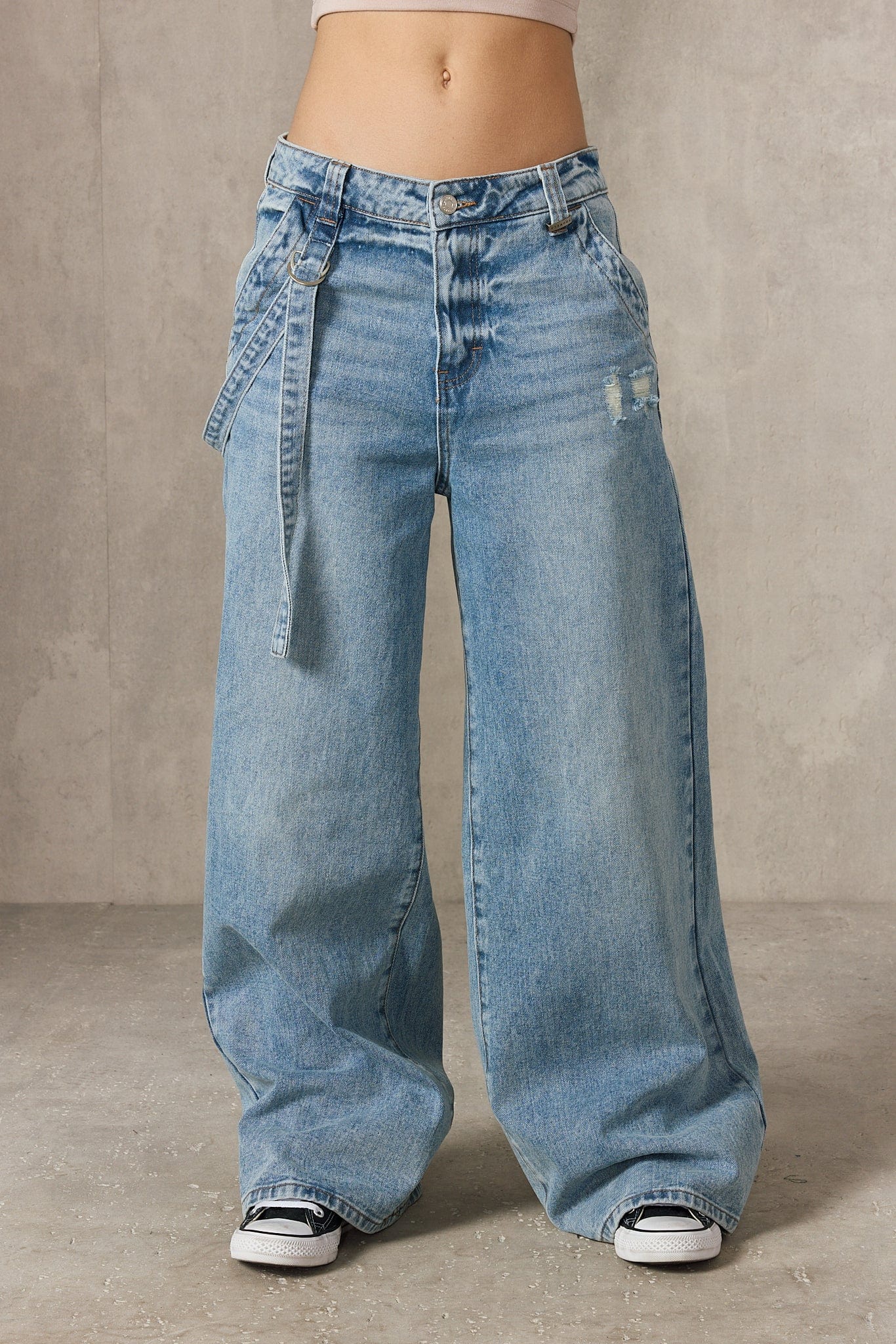 Front view of the model in oversized buckle detail jeans.