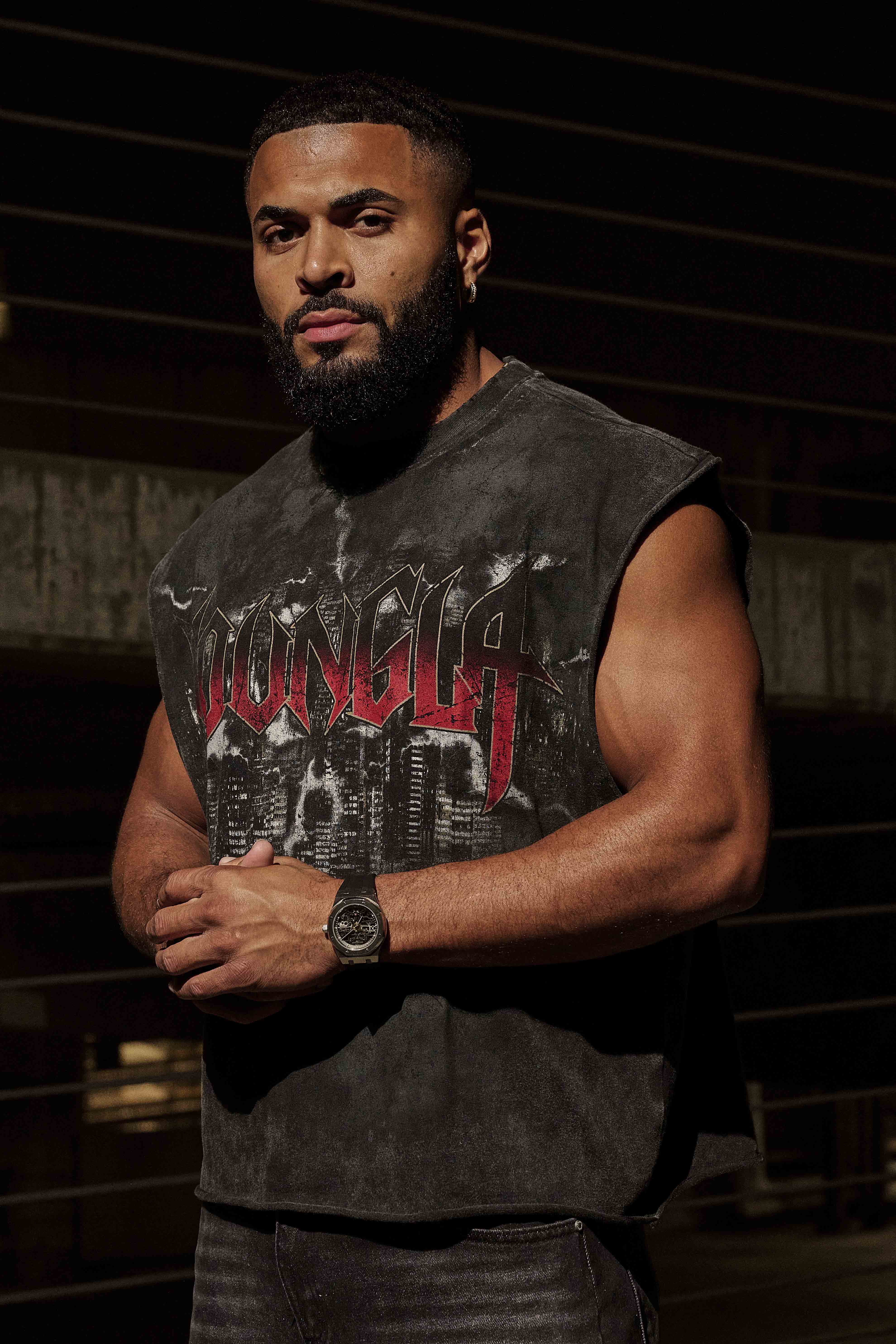 Model wearing cropped graphic tank top in urban setting.